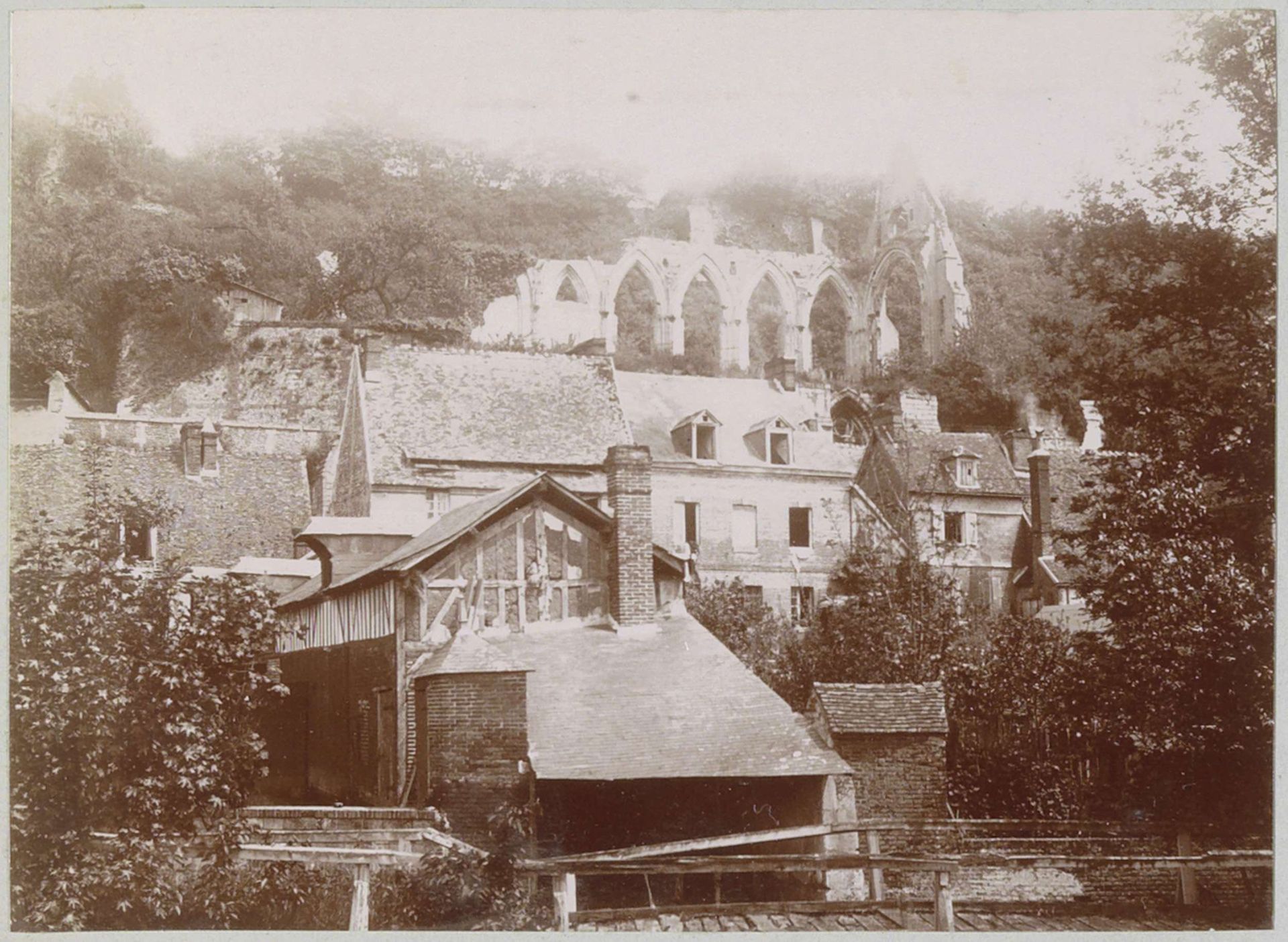 Gezicht op Beaumont-le-Roger met huizen en kerkruïne by Delizy