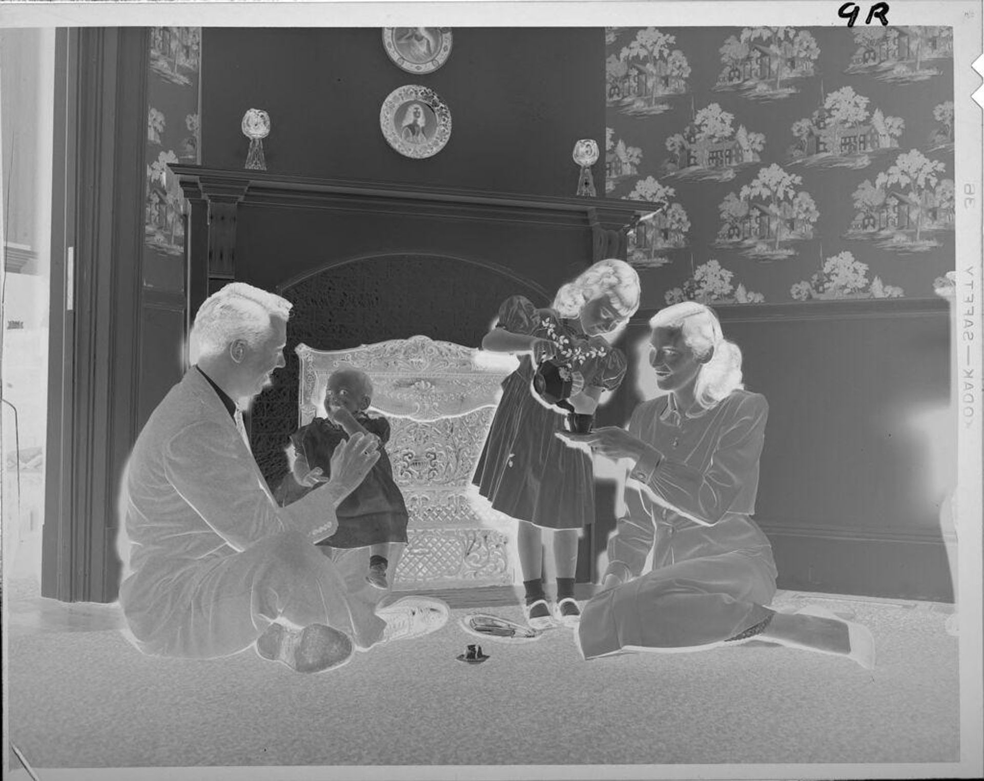 Untitled (family having tea party in front of fireplace) by Lucian and Mary Brown