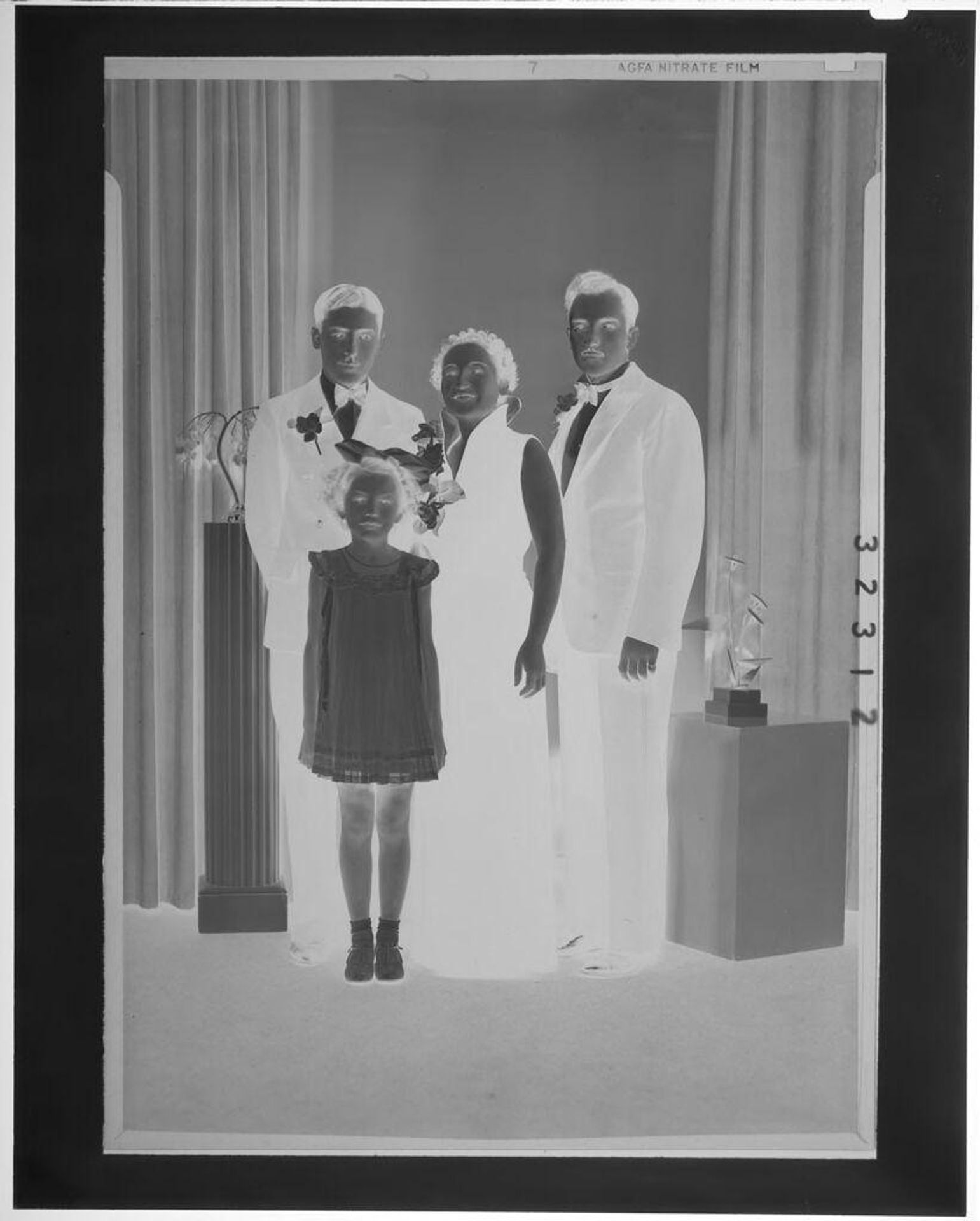 Untitled (studio portrait of woman and two men in formalwear with young girl in dress) by Martin Schweig