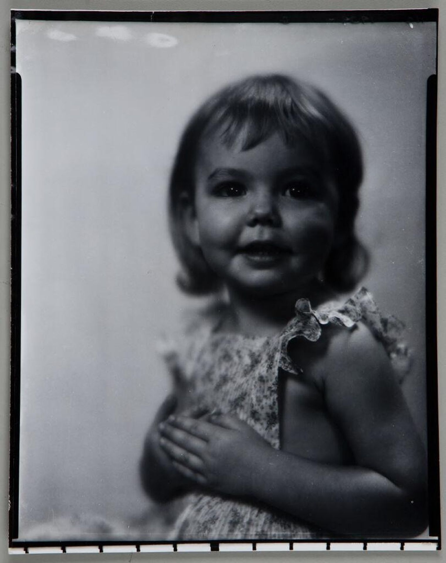 Untitled (little girl in sleeveless dress with hands in front of chest) by Paul Gittings