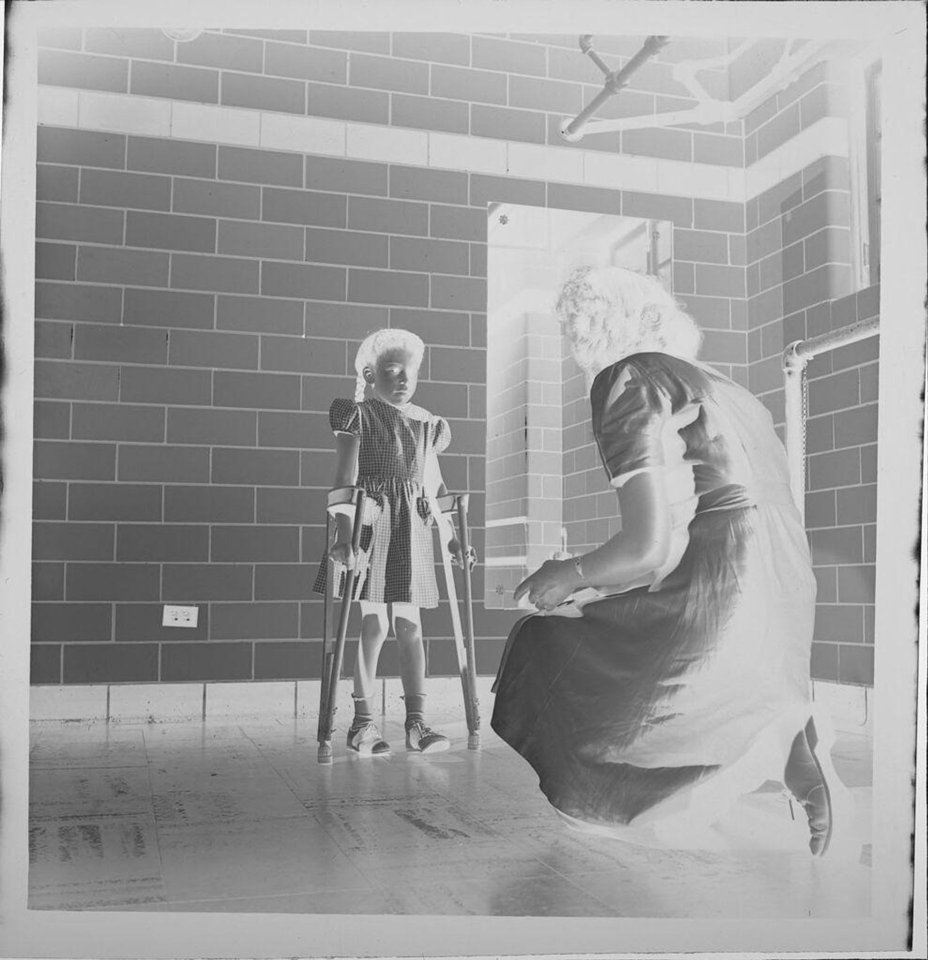 Untitled (child on crutches with nurse) by Jack Gould