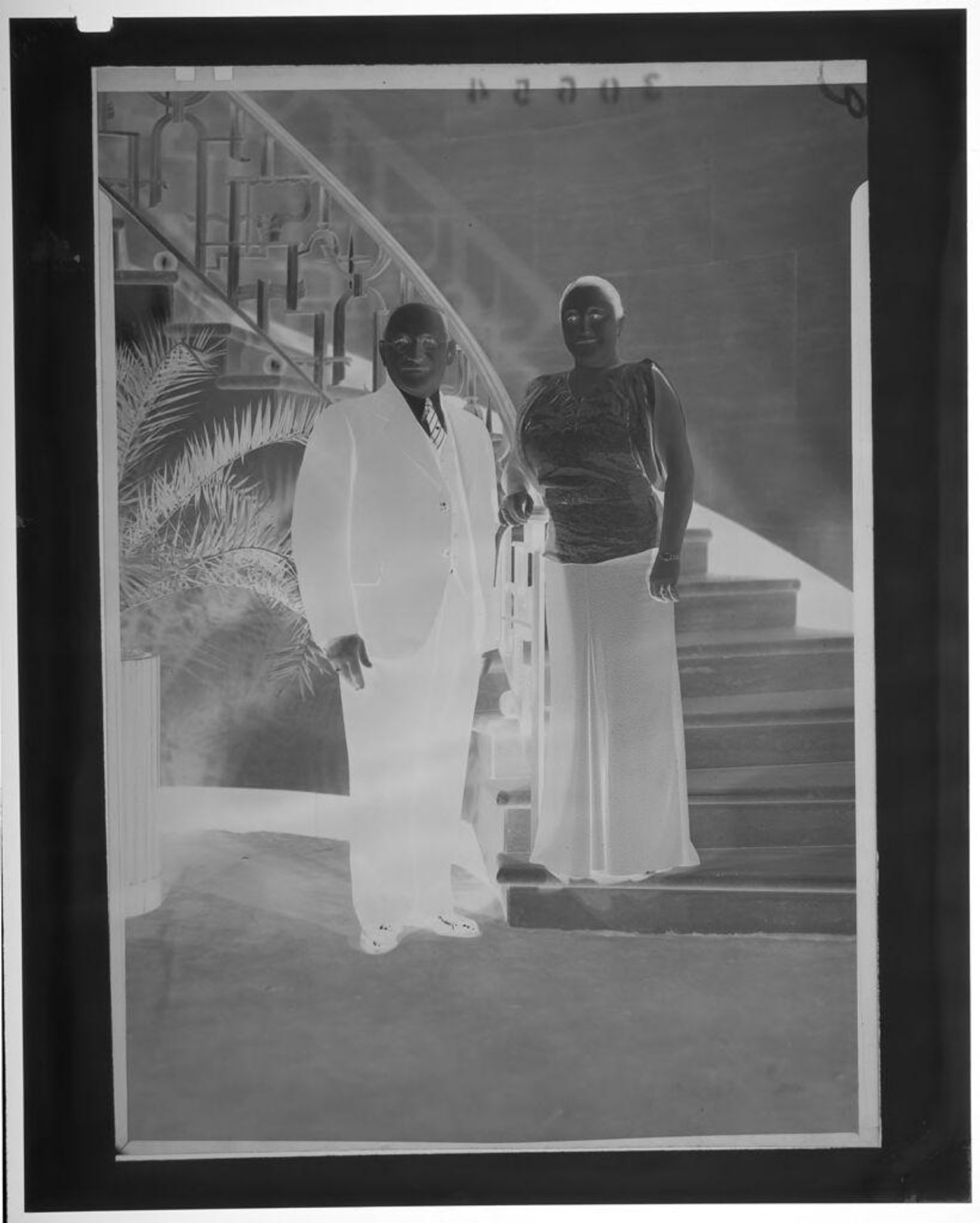 Untitled (middle-aged couple posed at bottom of winding staircase) by Martin Schweig