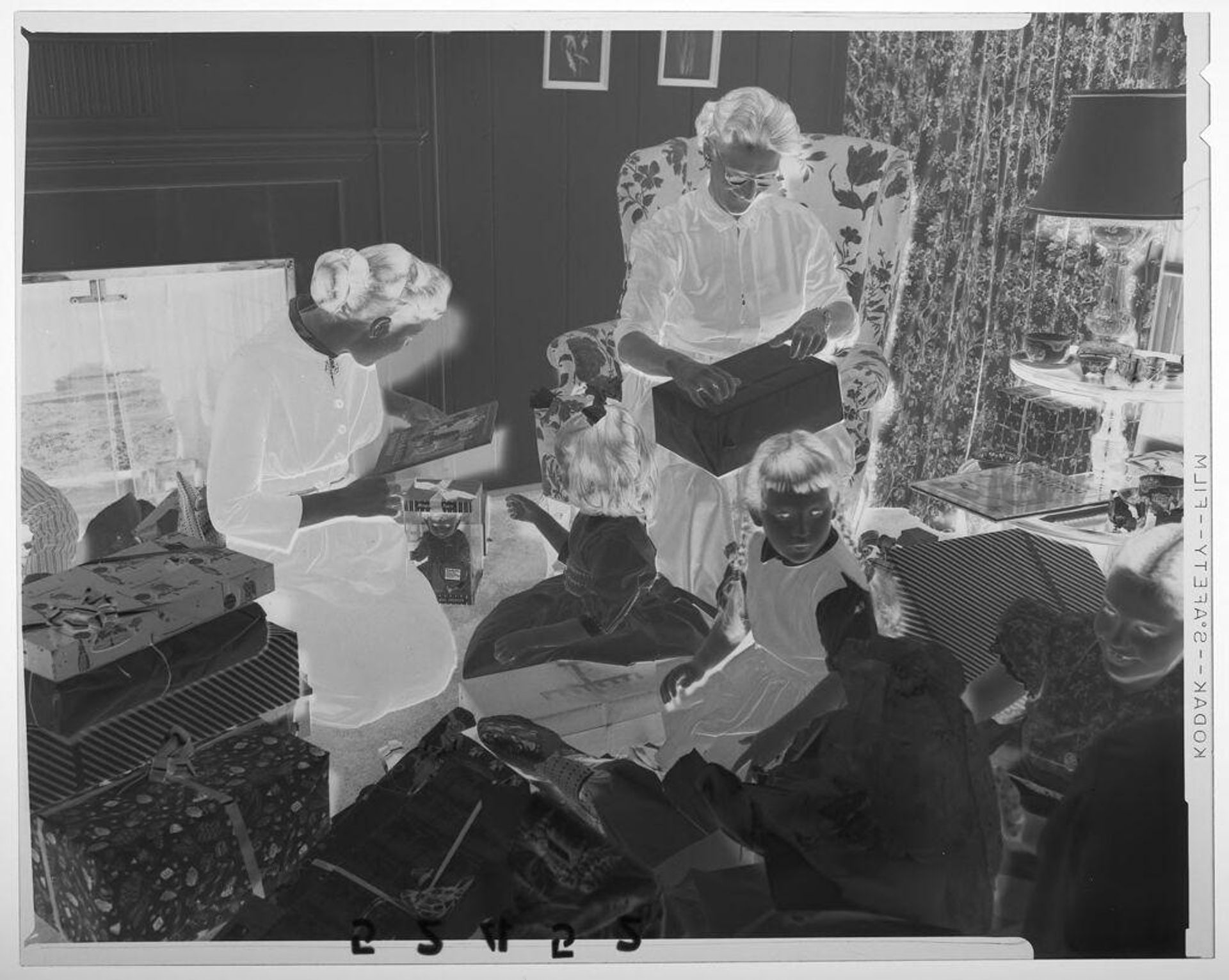 Untitled (two women and three children opening Christmas gifts in living room) by Martin Schweig