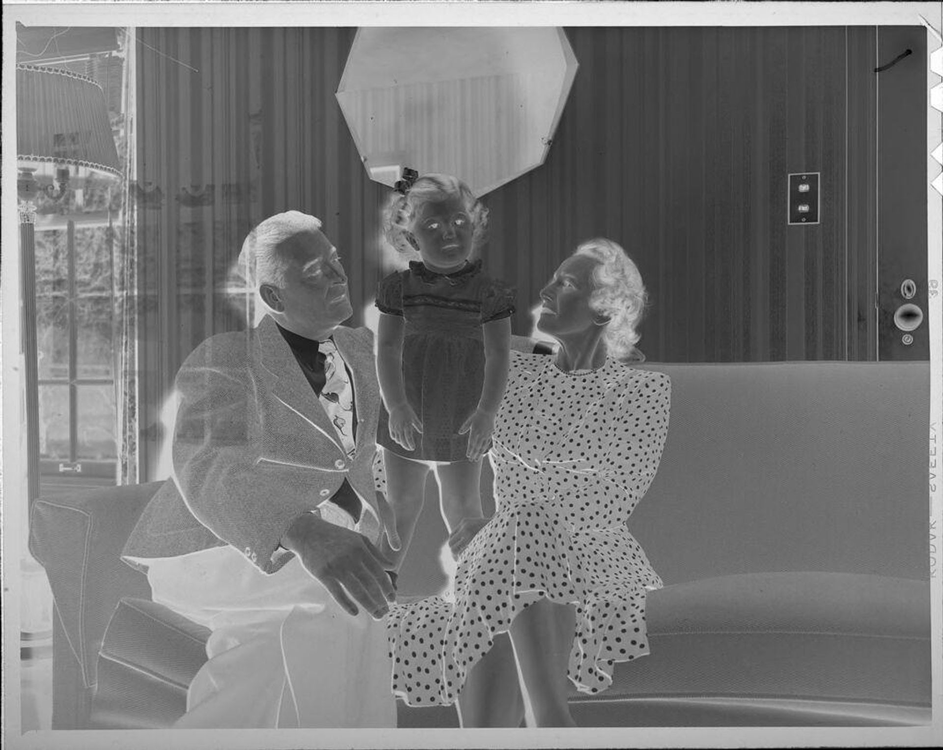 Untitled (man, woman, and girl on couch) by Lucian and Mary Brown