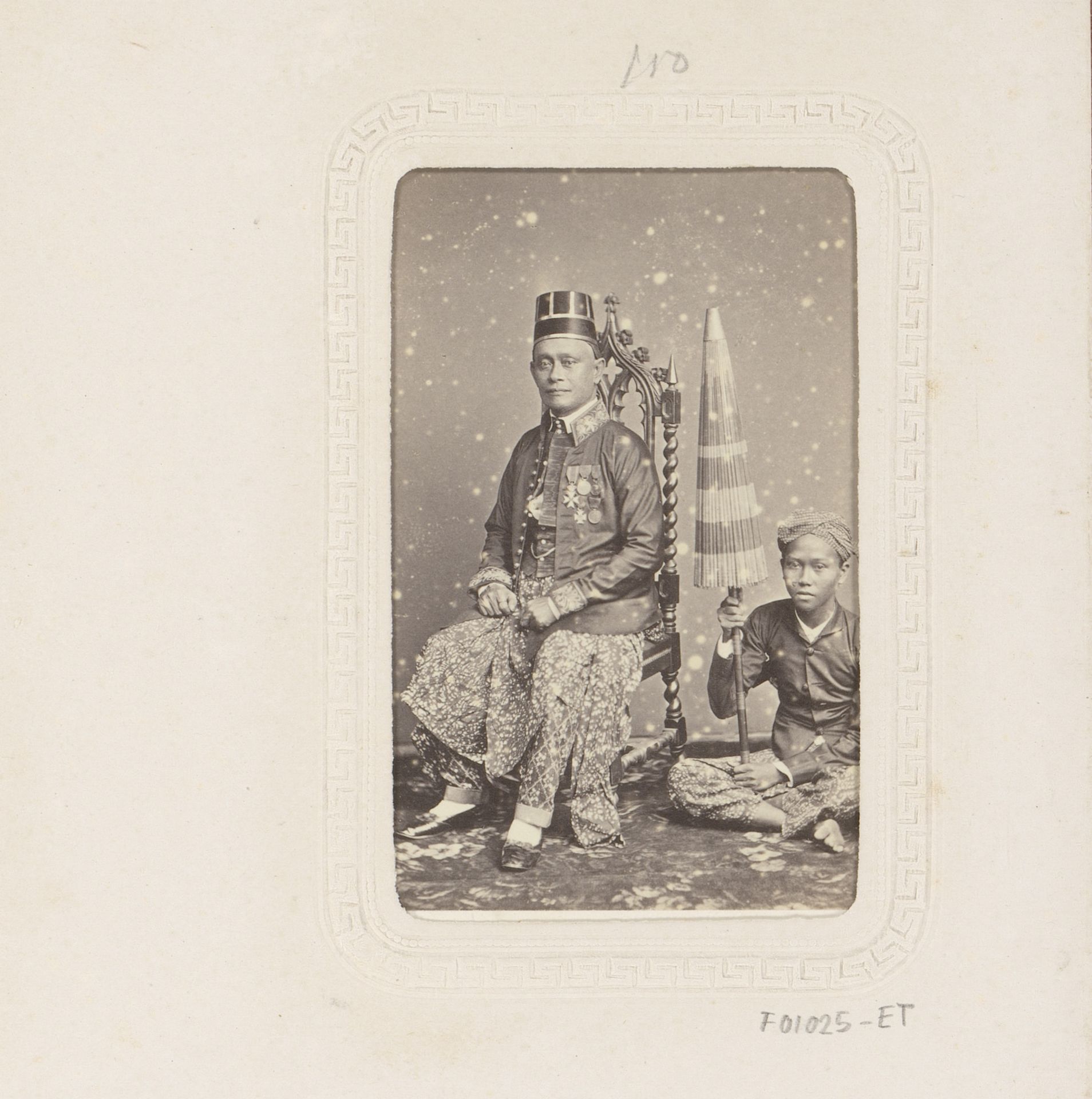Portret van een Indonesische man met jongen met parasol by Woodbury & Page
