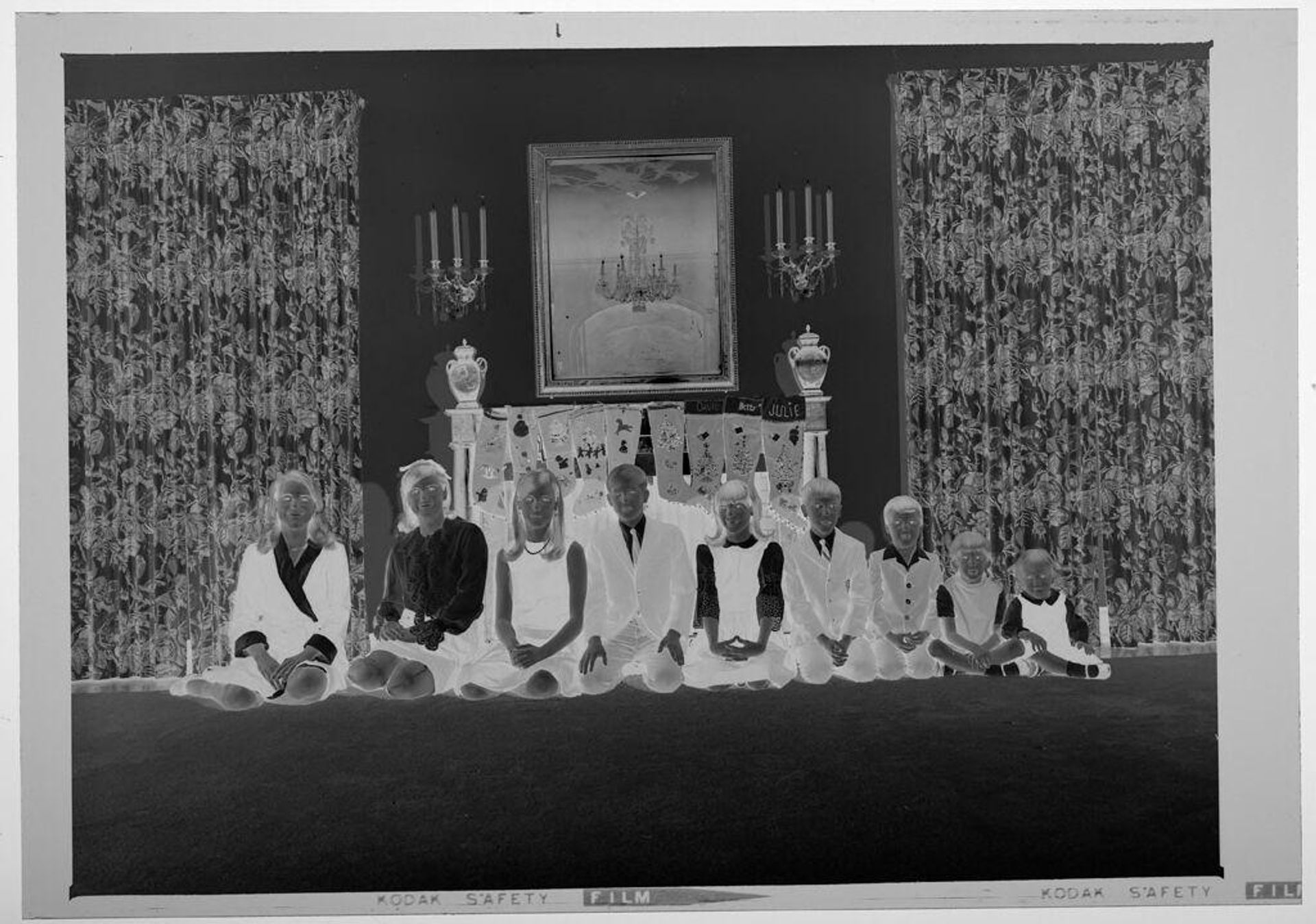 Untitled (nine children posed sitting in front of fireplace decorated with stockings) by Martin Schweig