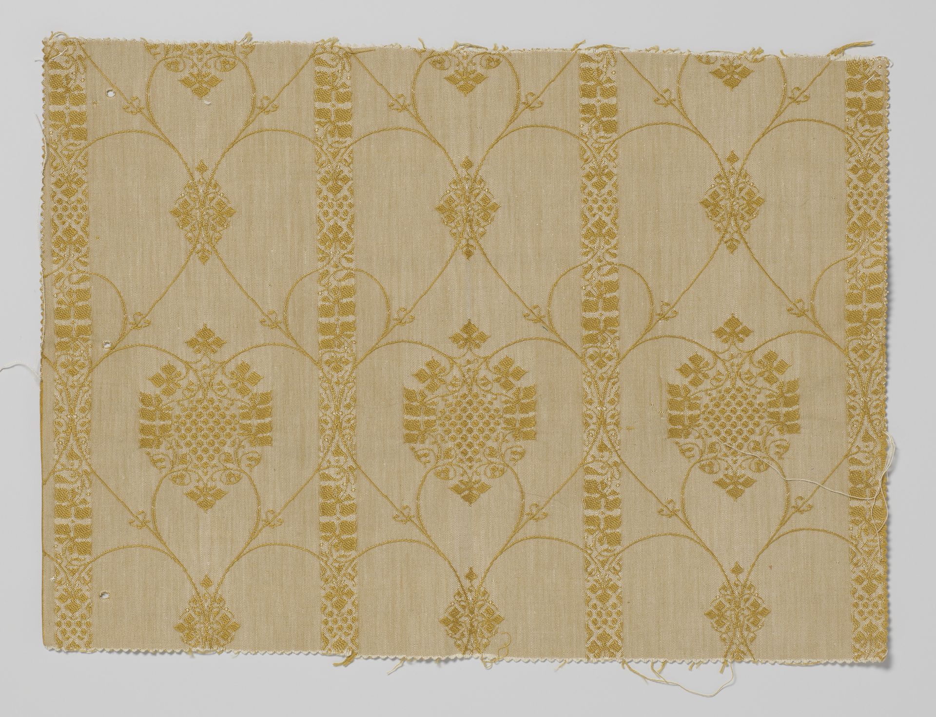 Fragment bespanningsstof met patroon van druivenranken tussen verticale strepen. Gele inslag op naturelkleurige ketting by Theo Nieuwenhuis