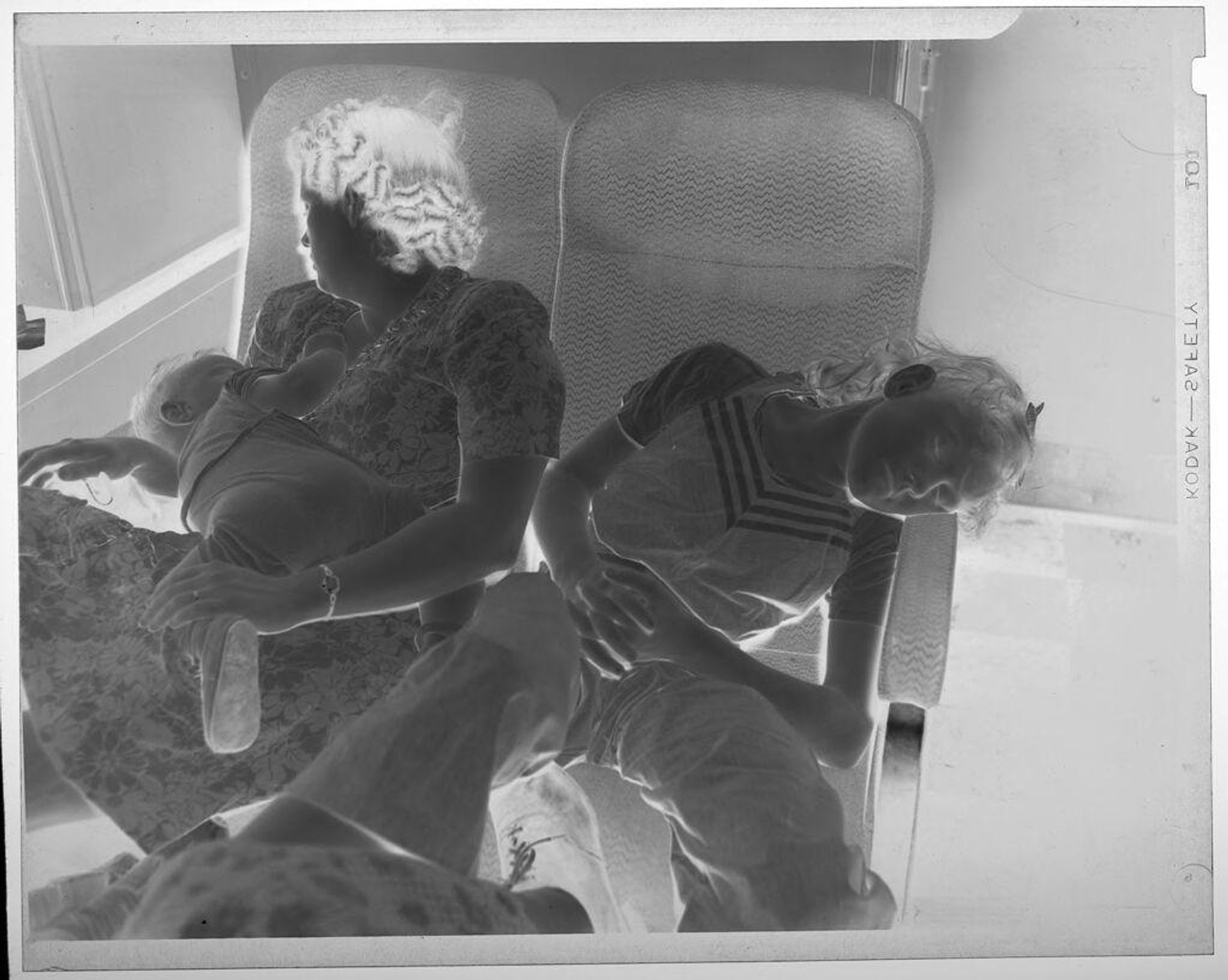 Untitled (woman and children sleeping on train seats) by Jack Gould