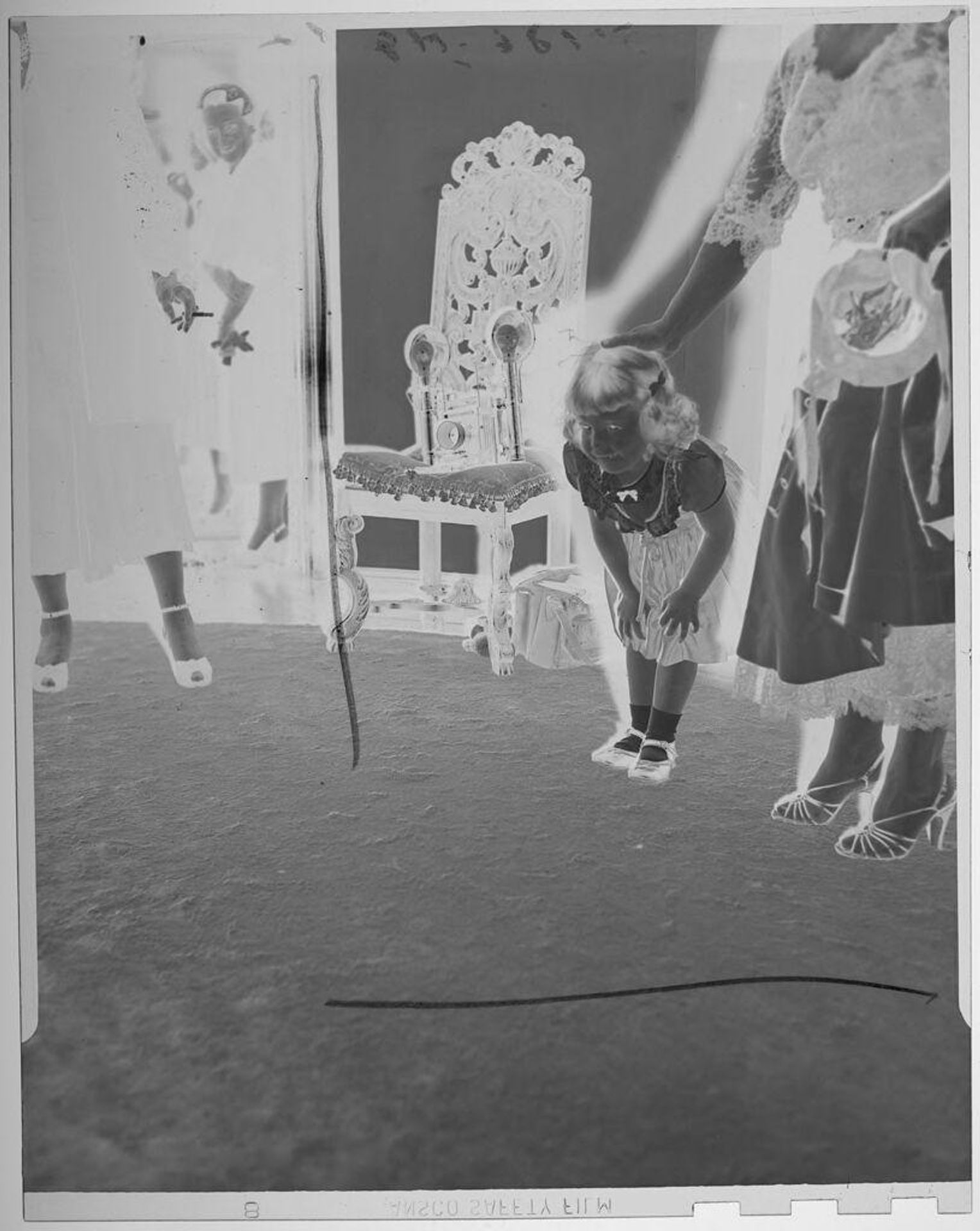 Untitled (little girl leaning over with hands on knees, looking at carpet) by Paul Gittings