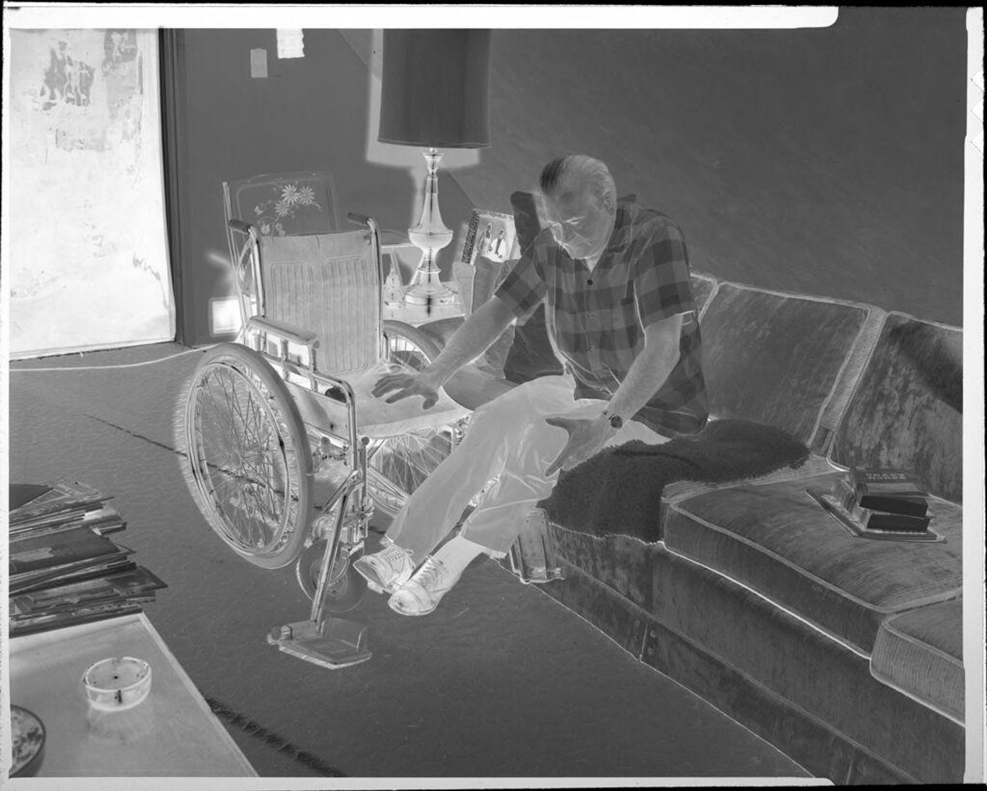 Untitled (man getting into wheelchair) by Ken Whitmire Associates