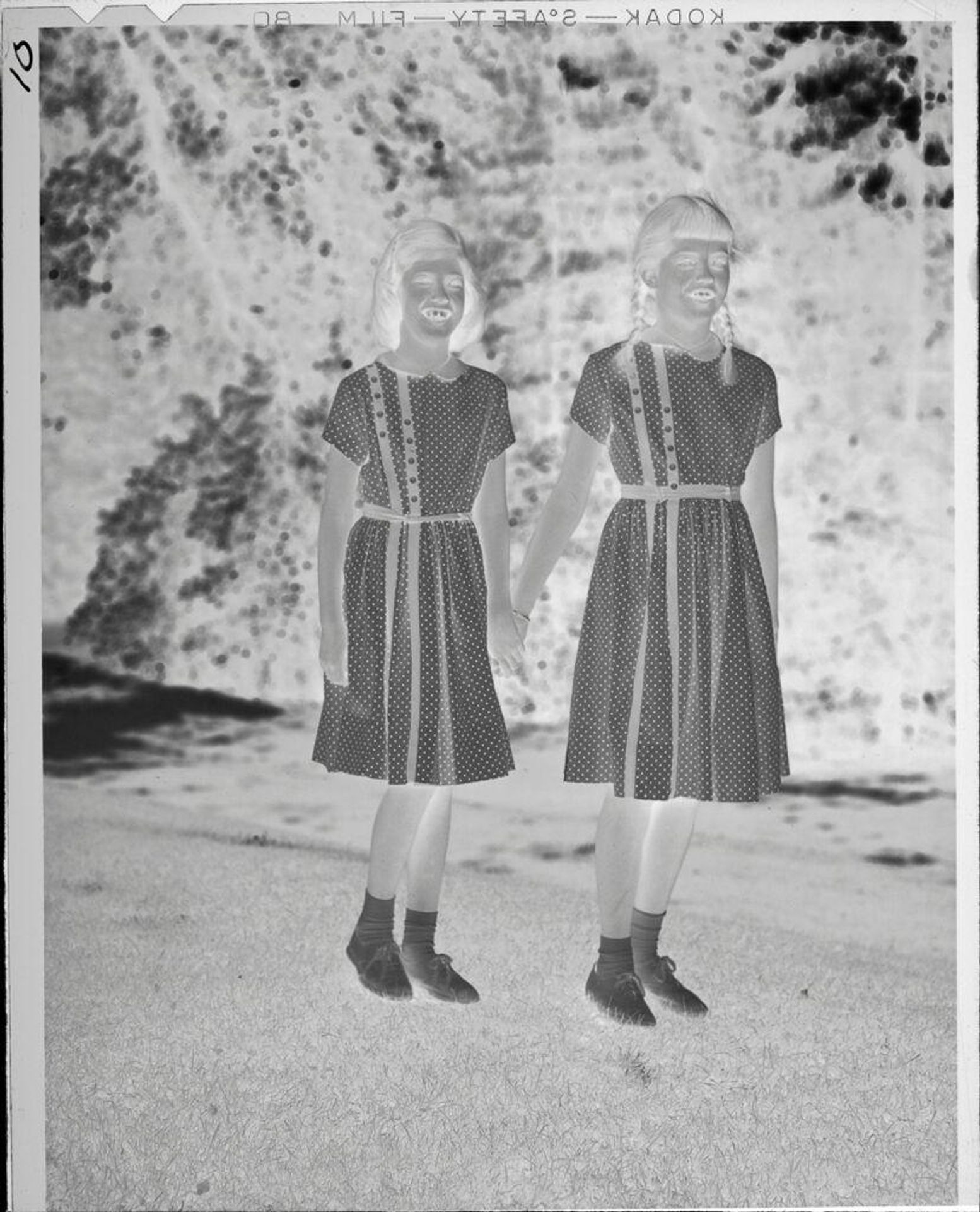 Untitled (two girls in matching dresses, standing outside) by Lucian and Mary Brown