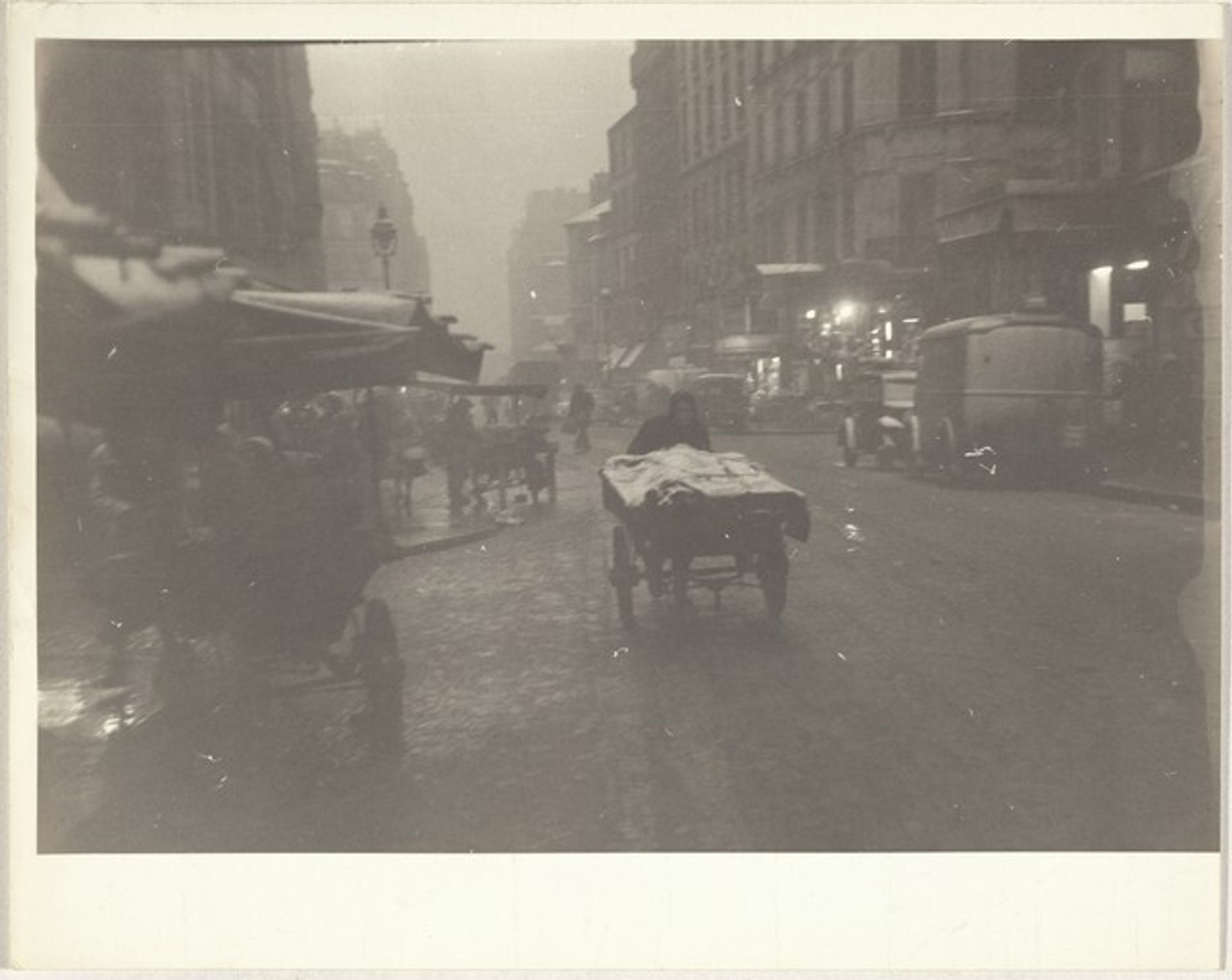 Vendor pushing cart in rain, Paris by Robert Frank
