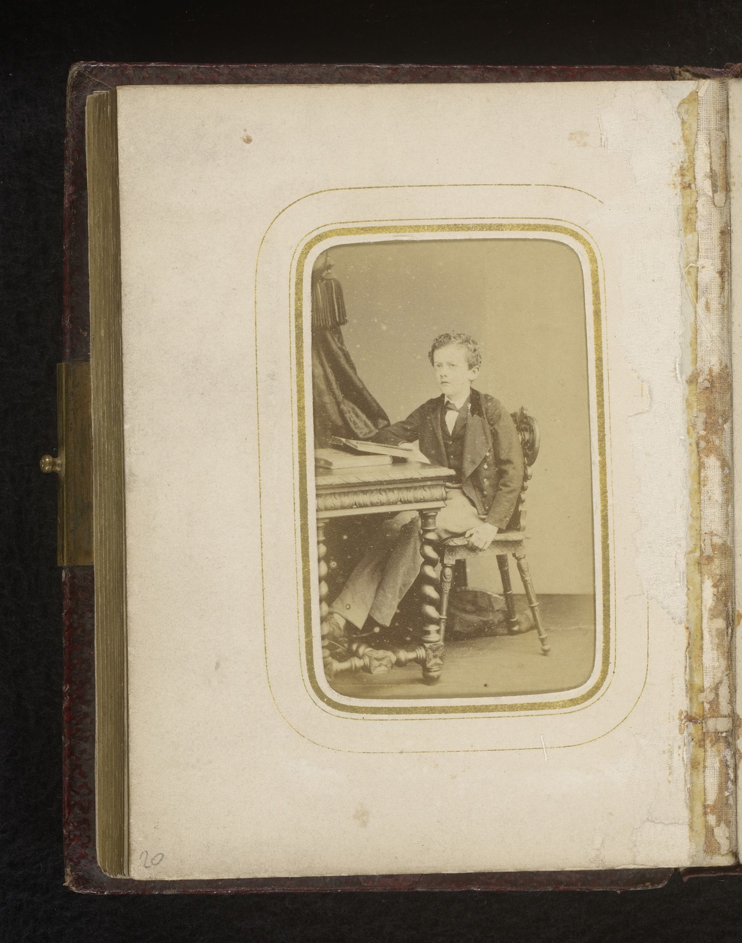 Portret van een jongen, zittend aan een bureau by L. Bacard