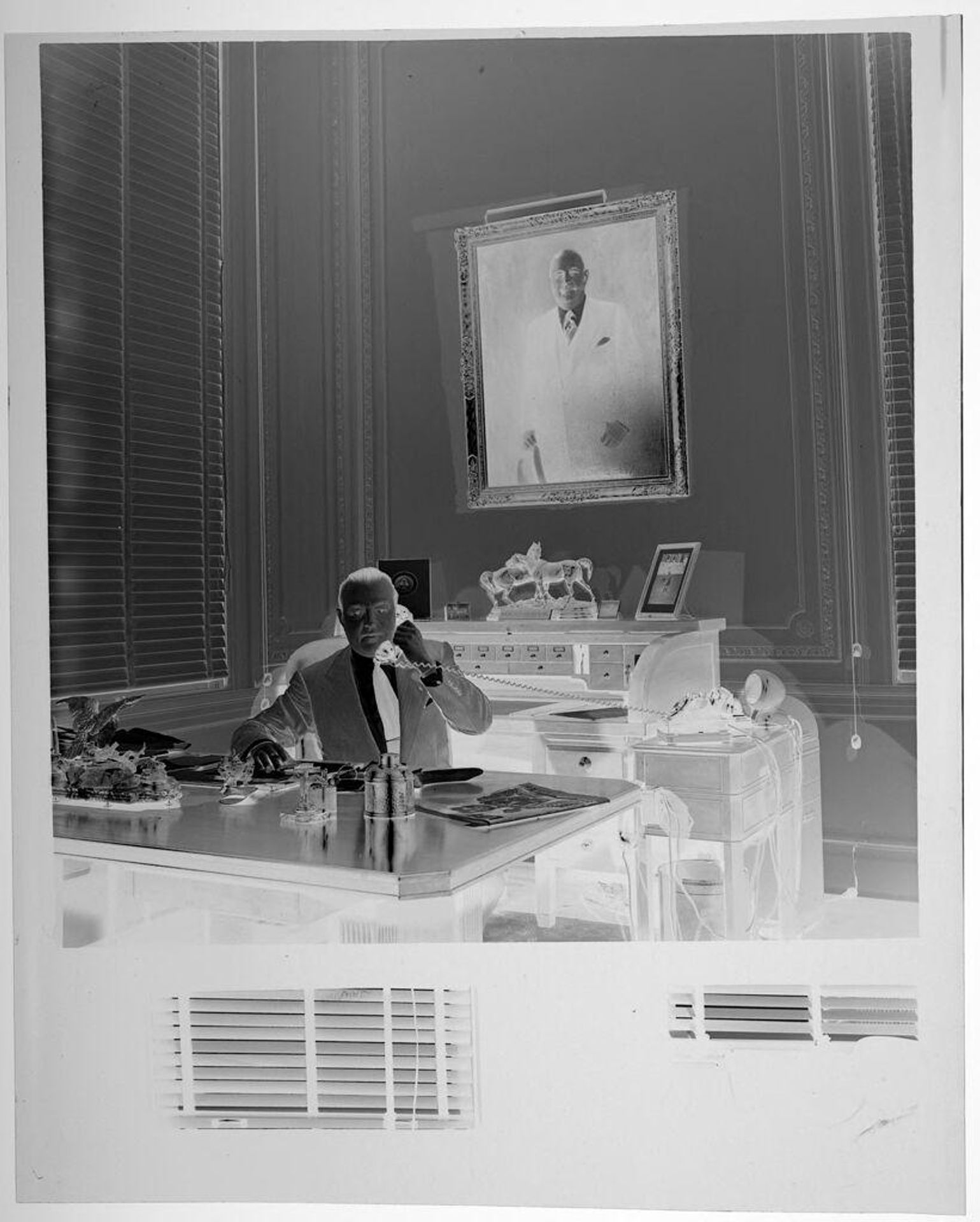 Untitled (man sitting behind desk talking on telephone) by Jack Gould
