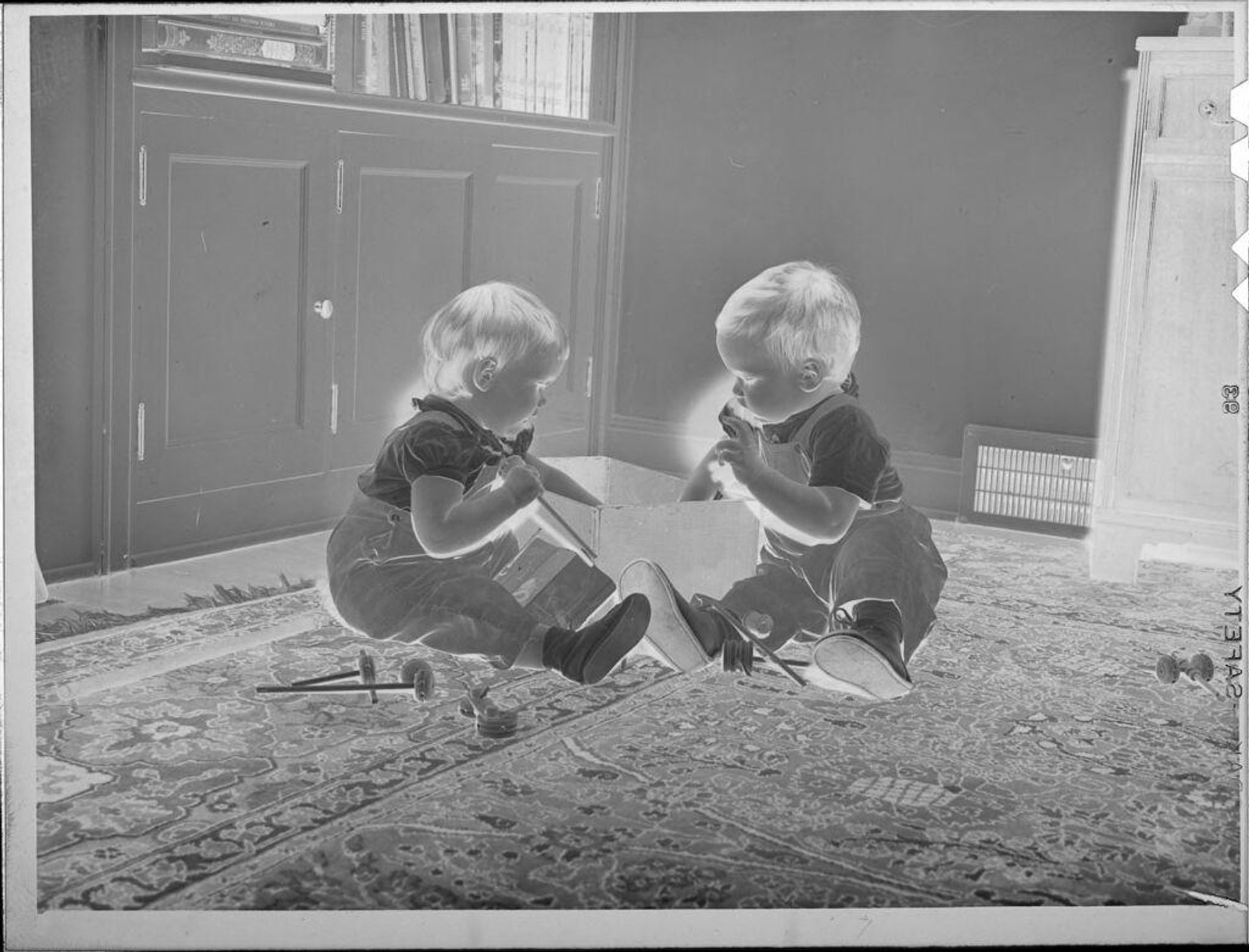 Untitled (two babies playing with toys in box) by Lucian and Mary Brown
