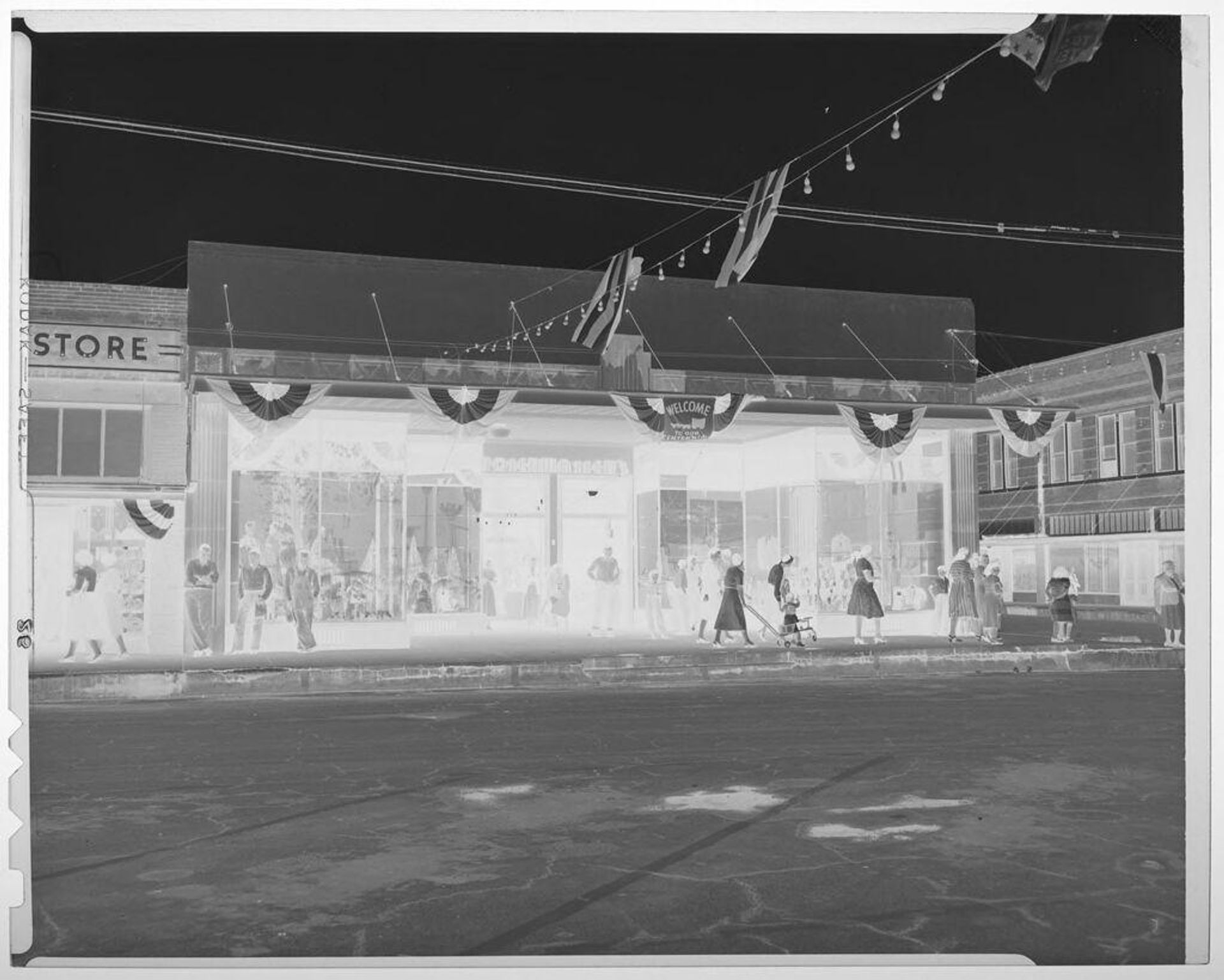Untitled (Centennial flags outside store with window  displays) by Harry Annas