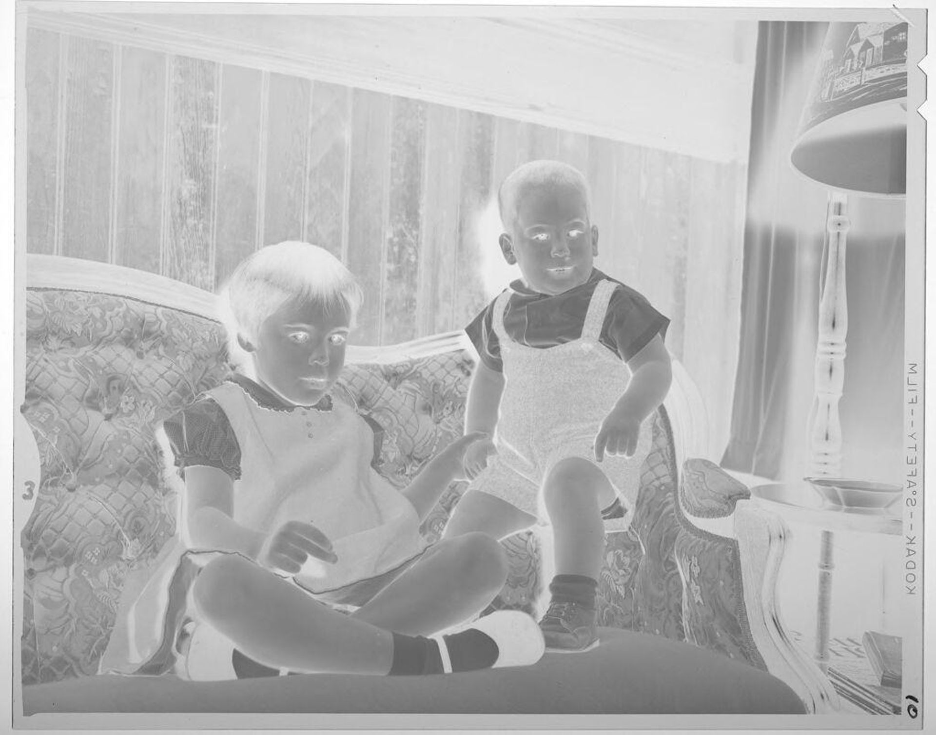 Untitled (girl and boy on couch) by Lucian and Mary Brown