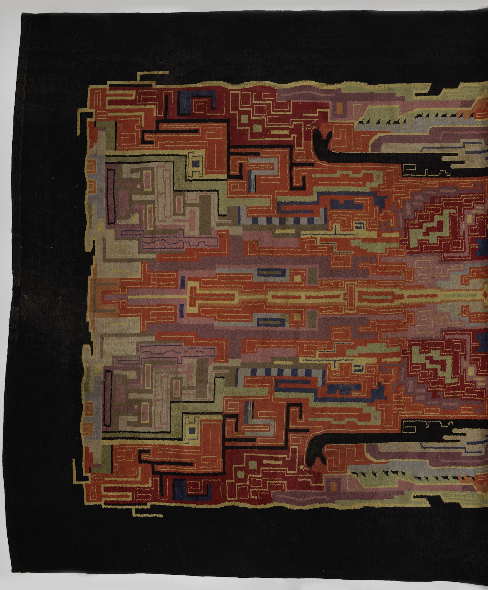 Vloerkleed met een kleurig art déco-patroon binnen een zwarte rand by Jaap Gidding