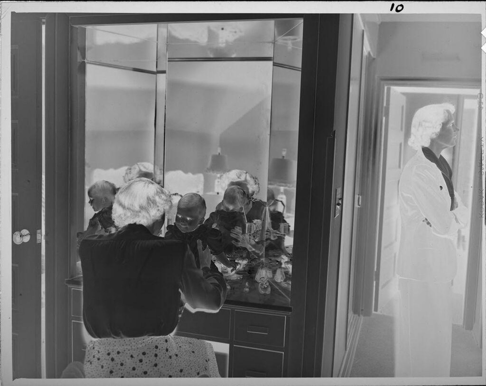 Untitled (woman and baby at vanity looking into mirror) by Lucian and Mary Brown