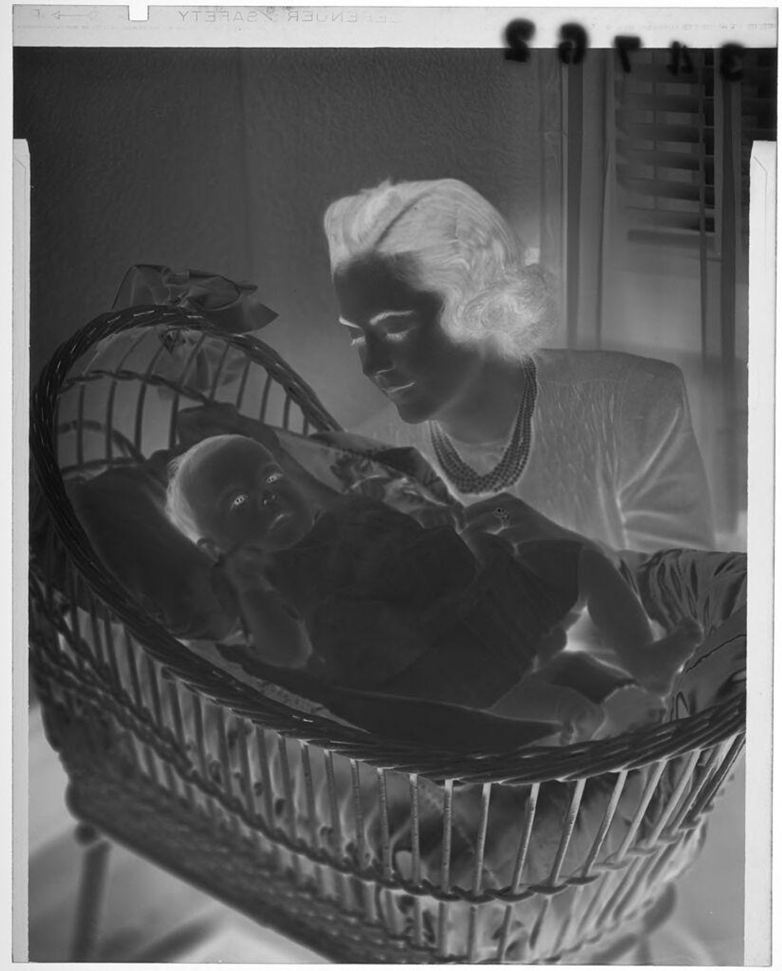 Untitled (woman looking over baby in crib) by Martin Schweig