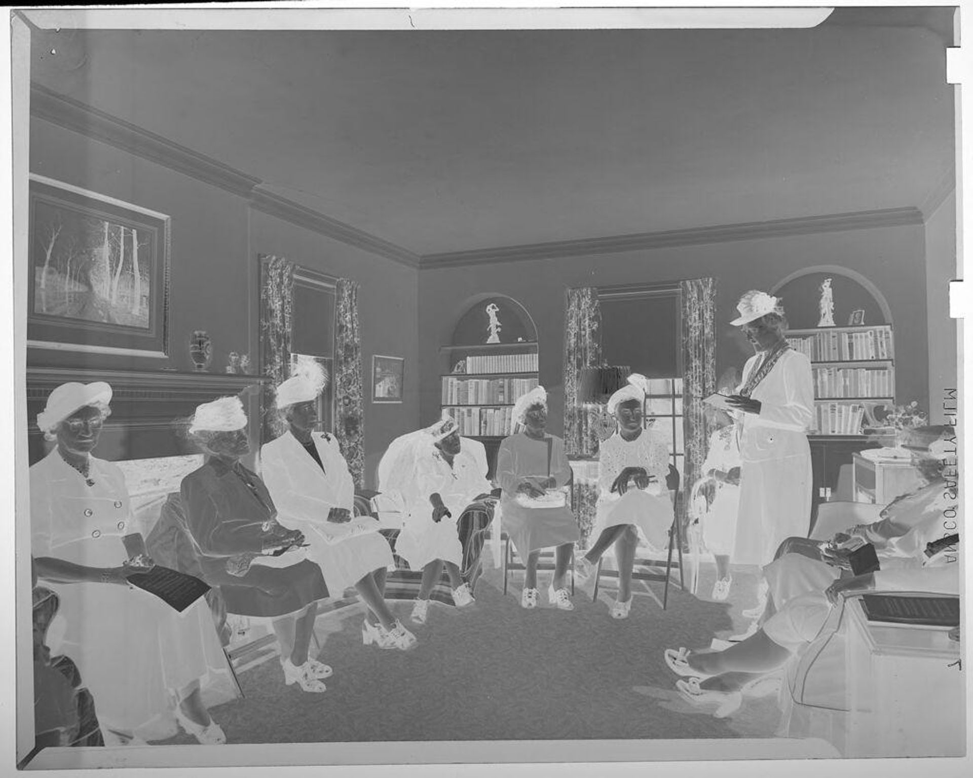 Untitled (several elderly women wearing hats sitting in living room during a meeting) by Jack Gould