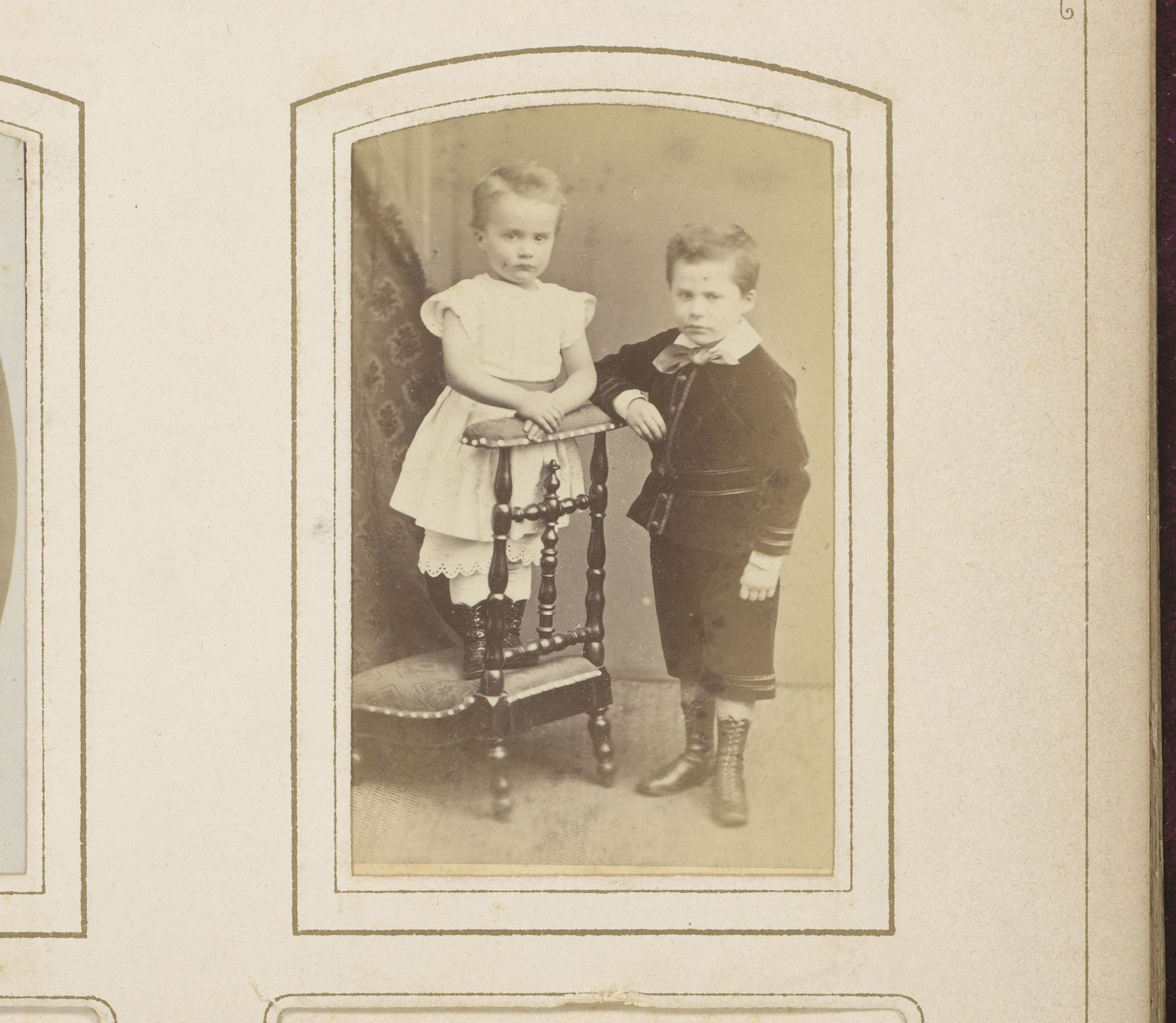 Portret van twee kinderen, waarvan één staand op een bidstoel by Albert Greiner