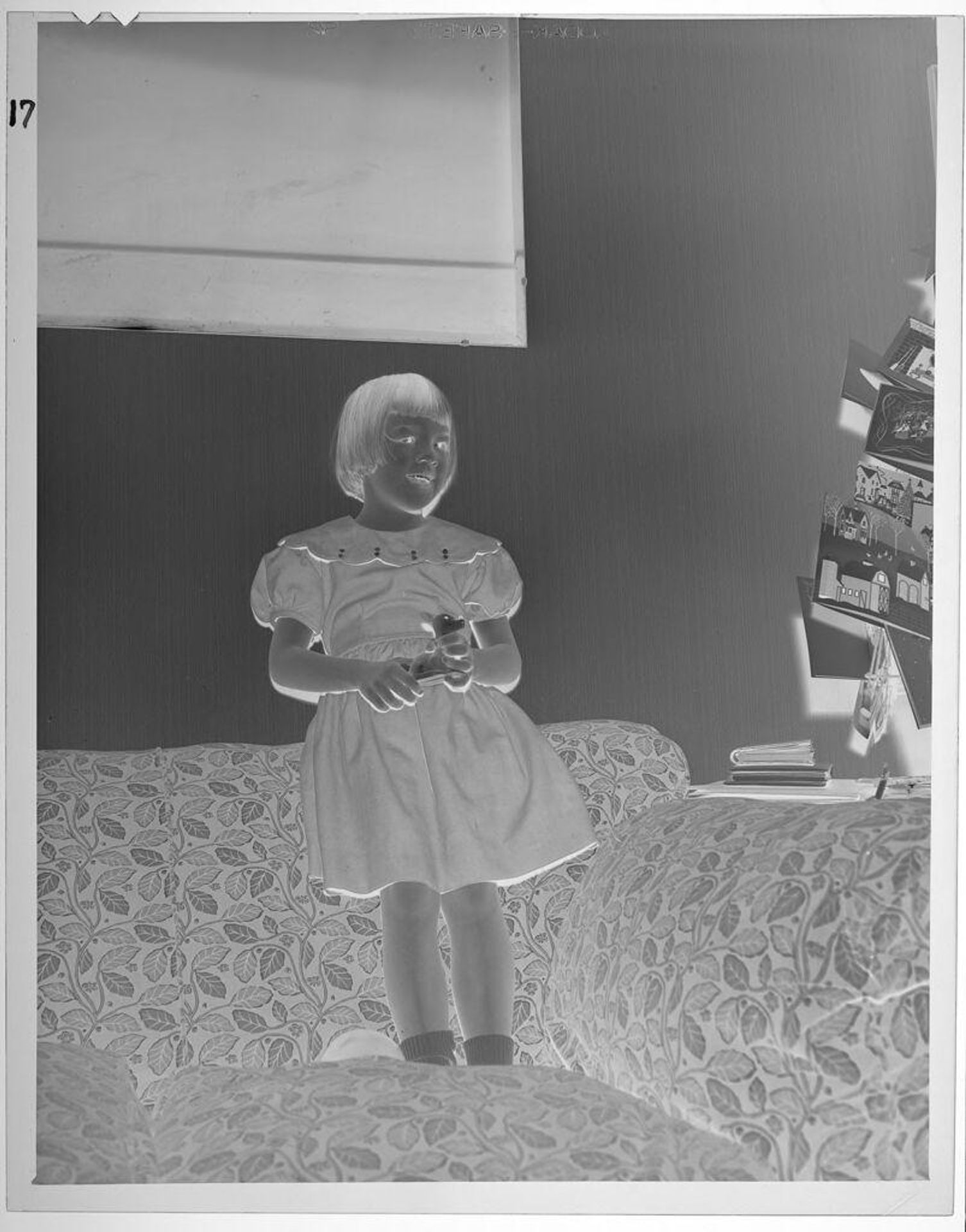Untitled (girl on couch holding small toy) by Lucian and Mary Brown