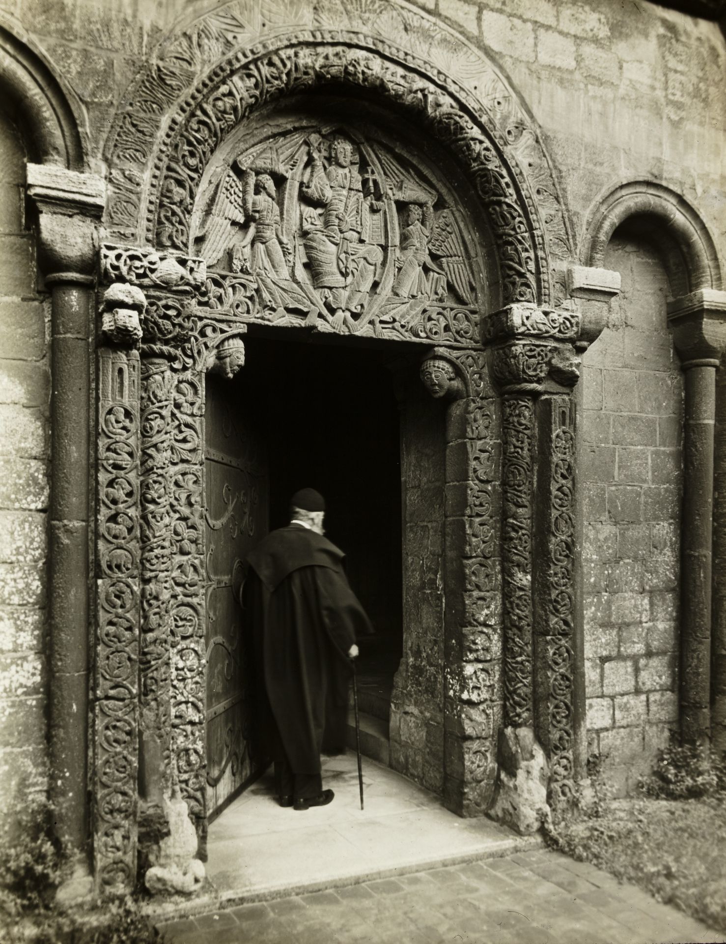 Ely Cathedral: Prior's Door, with Bedesman by Frederick H. Evans