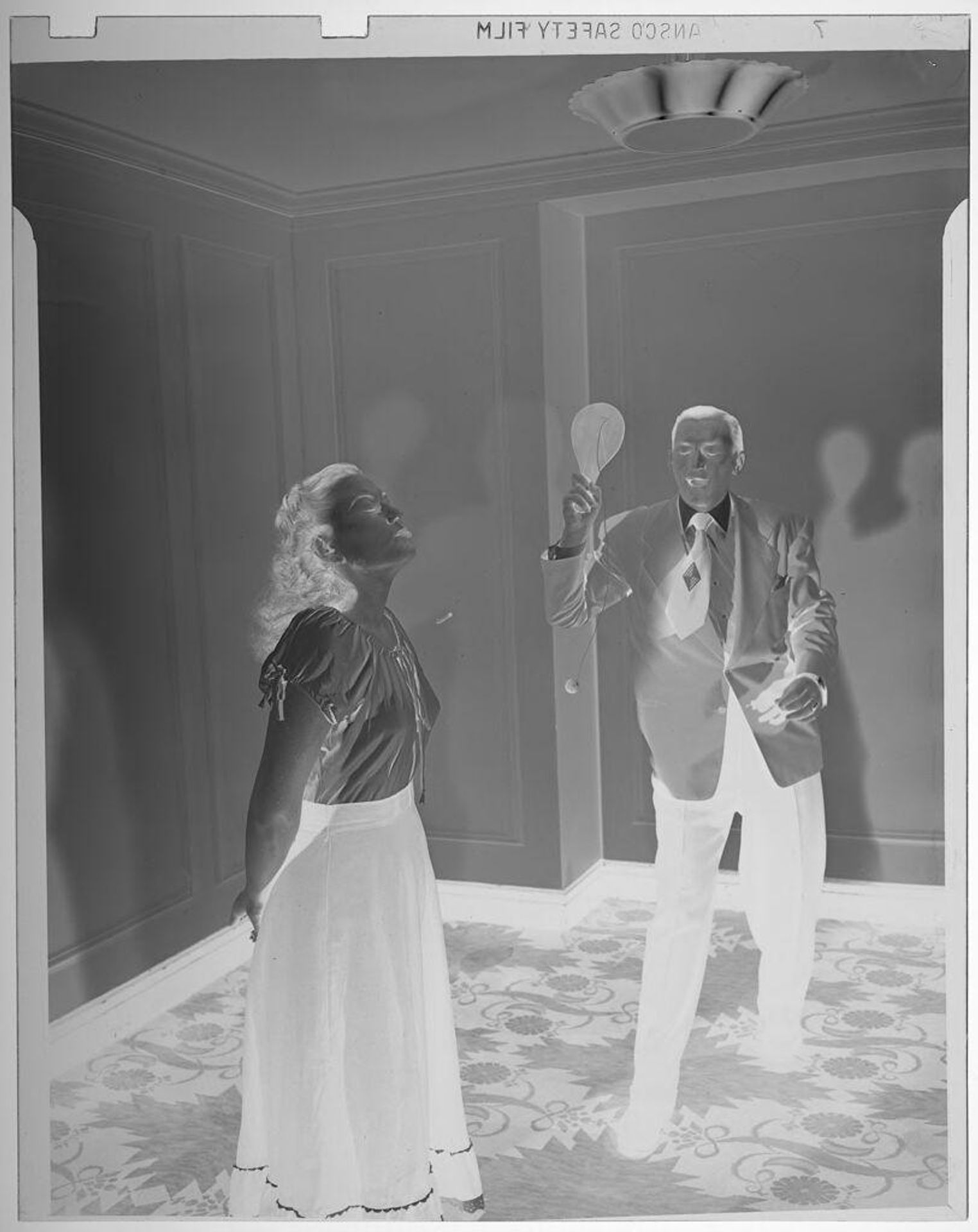 Untitled (man and woman playing with paddle ball) by Jack Gould