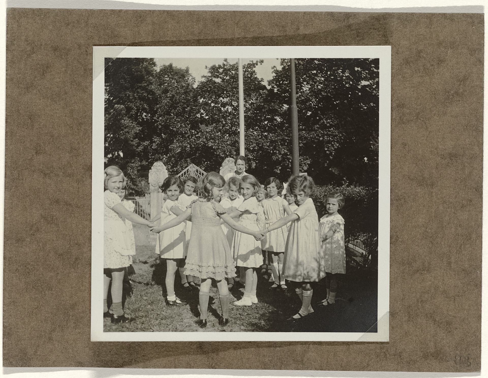 Isabel Wachenheimer met onbekende kinderen op een kinderfeestje in een tuin by Anonymous