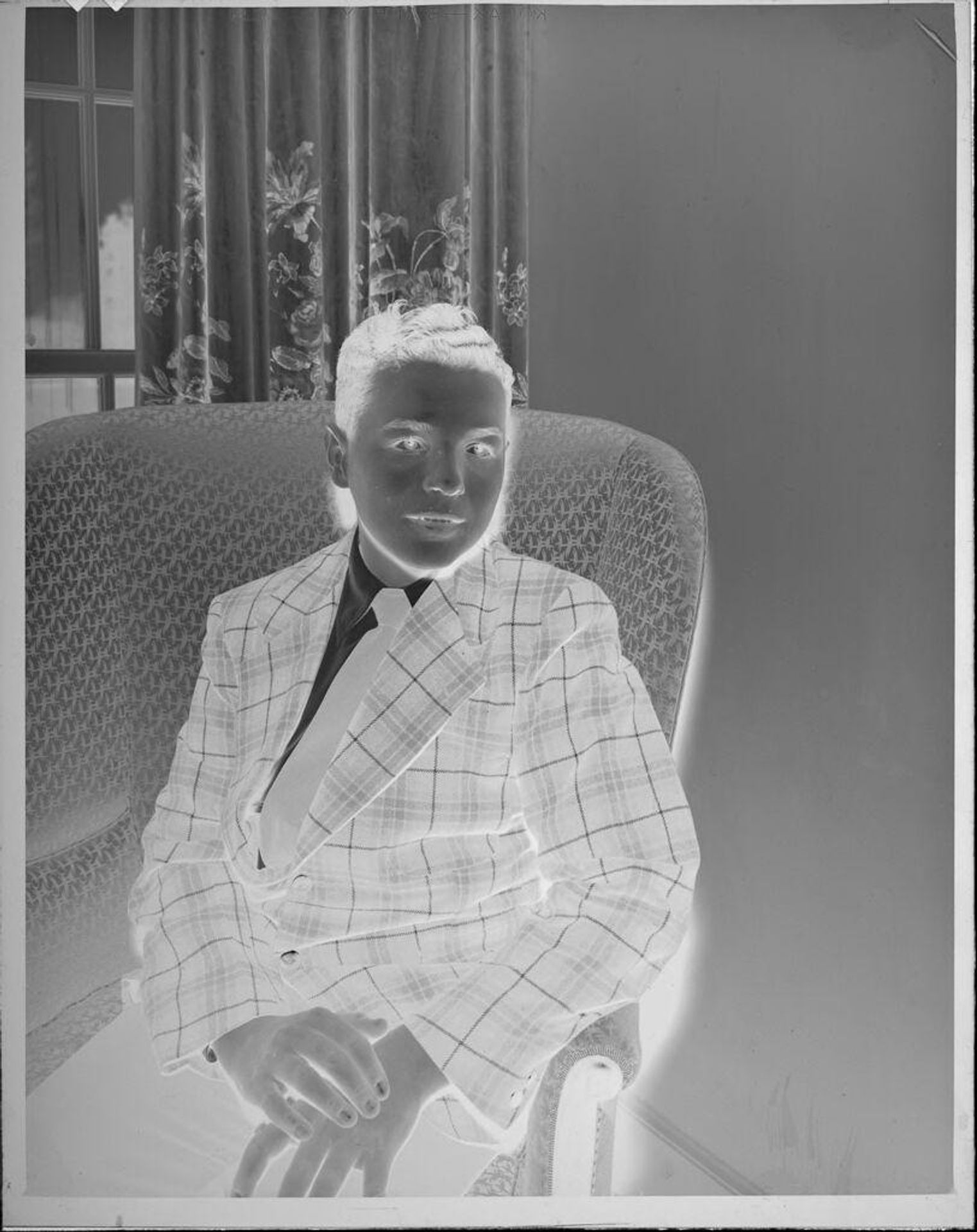 Untitled (boy in jacket and tie sitting in chair) by Lucian and Mary Brown