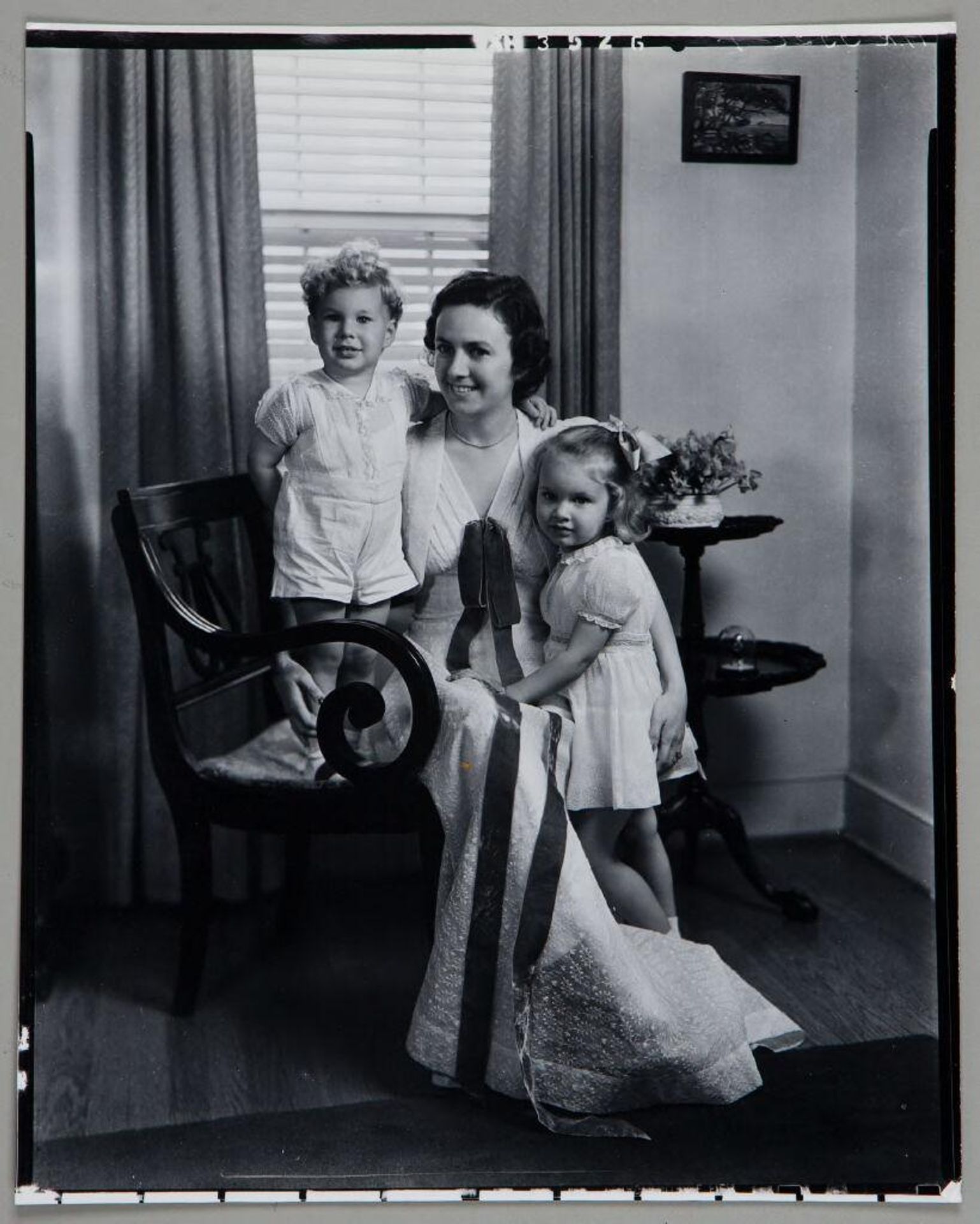 Untitled (woman seated in chair with son and daughter at her sides) by Paul Gittings