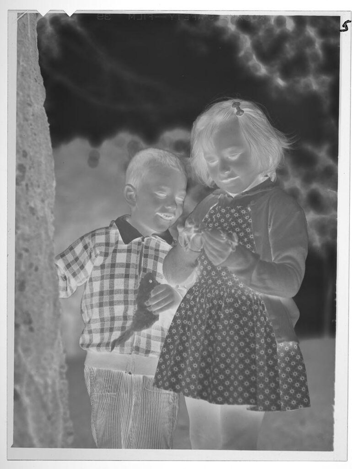Untitled (boy and girl standing by tree) by Lucian and Mary Brown