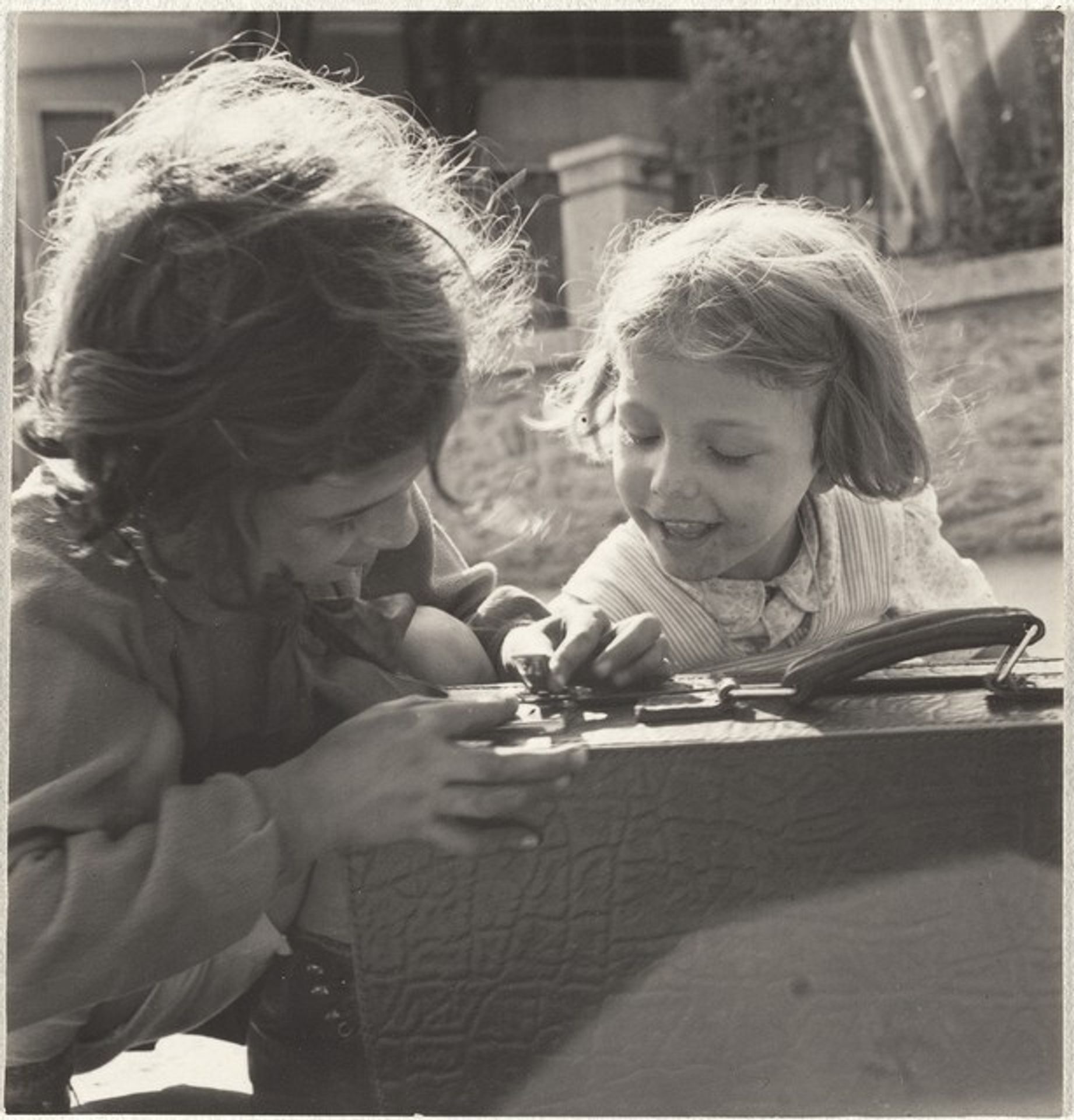 Girls playing with suitcase--Children by Robert Frank