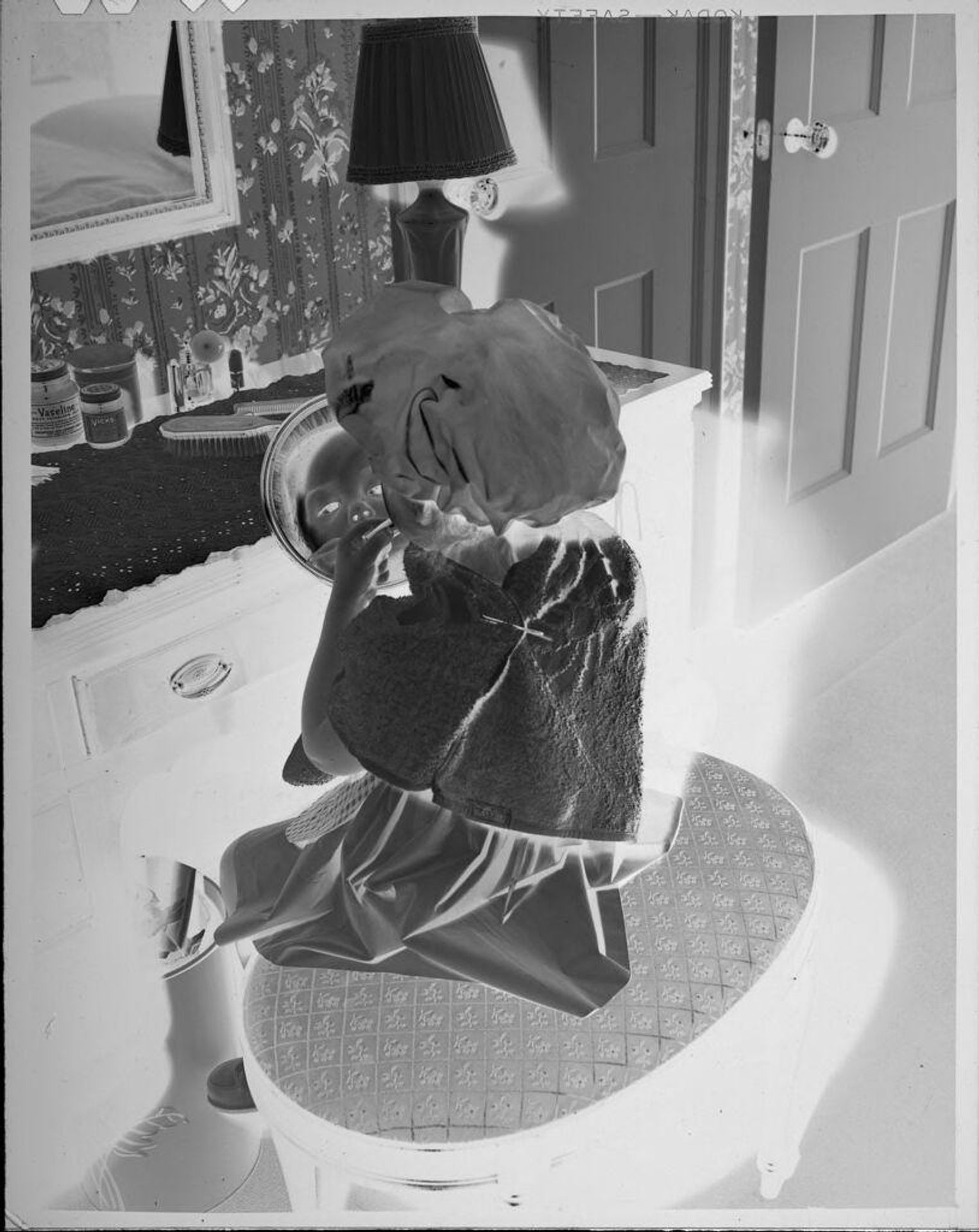 Untitled (little girl at vanity looking into small mirror) by Lucian and Mary Brown