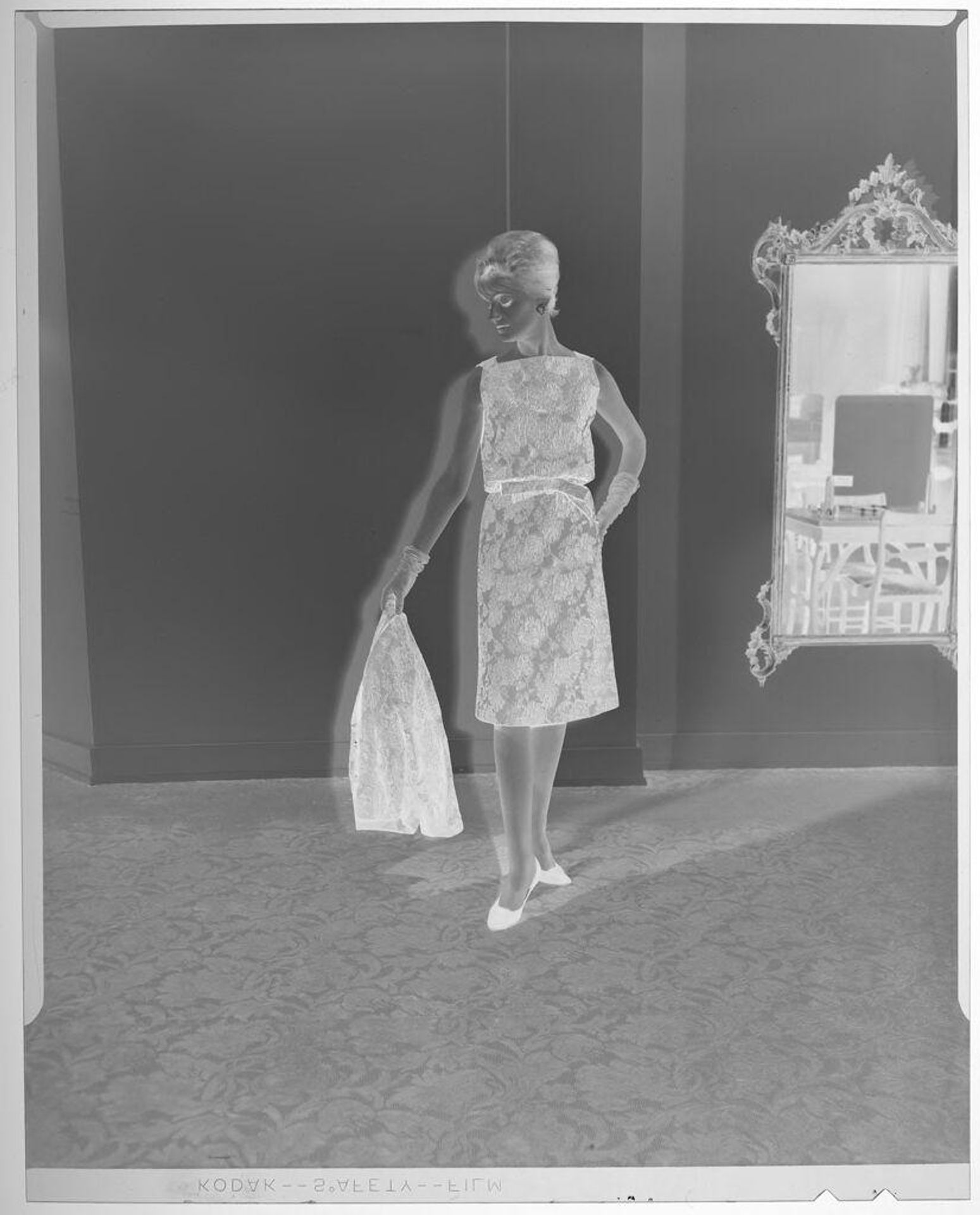 Untitled (fashion portrait of woman wearing sleevless patterned dress holding matching coat) by Martin Schweig