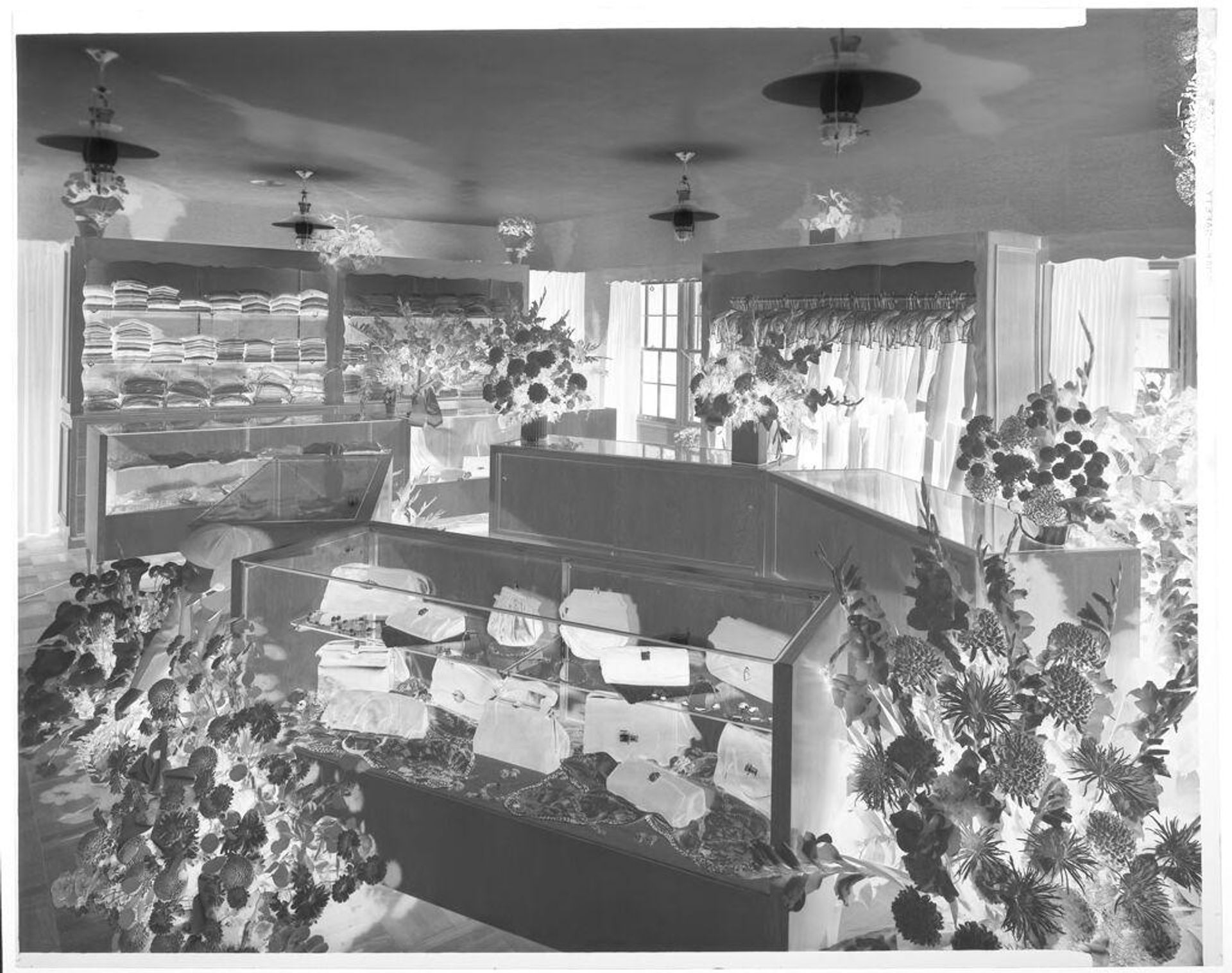 Untitled (women's clothing store interior with many bouquets of flowers) by John Deusing