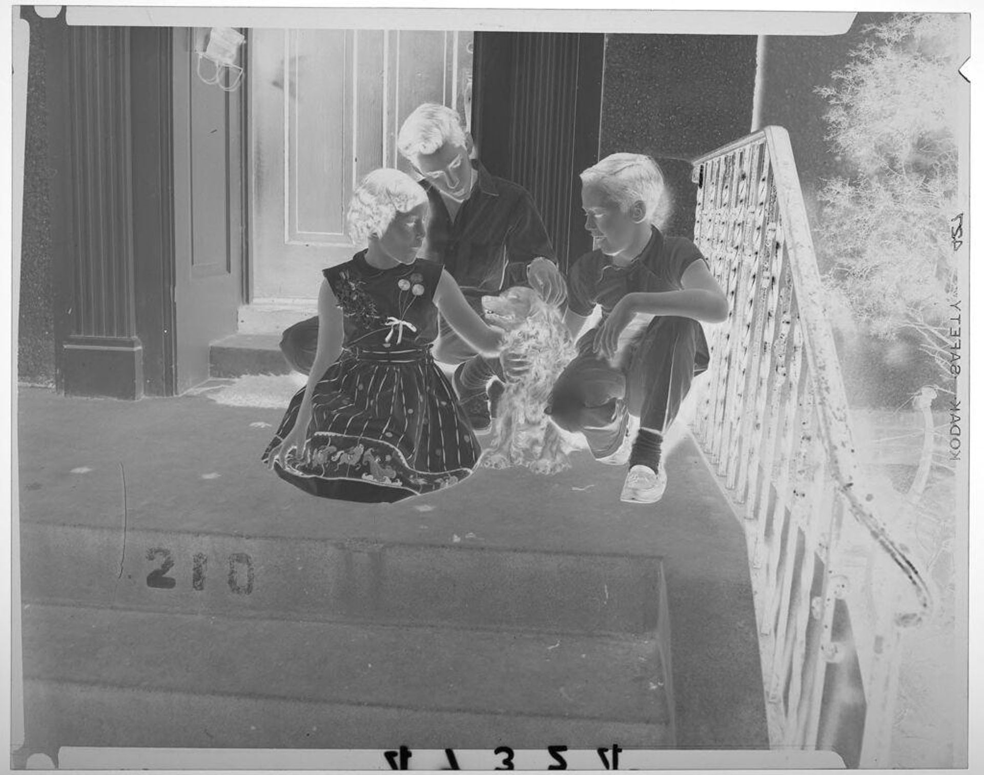 Untitled (three children petting dog on front steps of house) by Martin Schweig