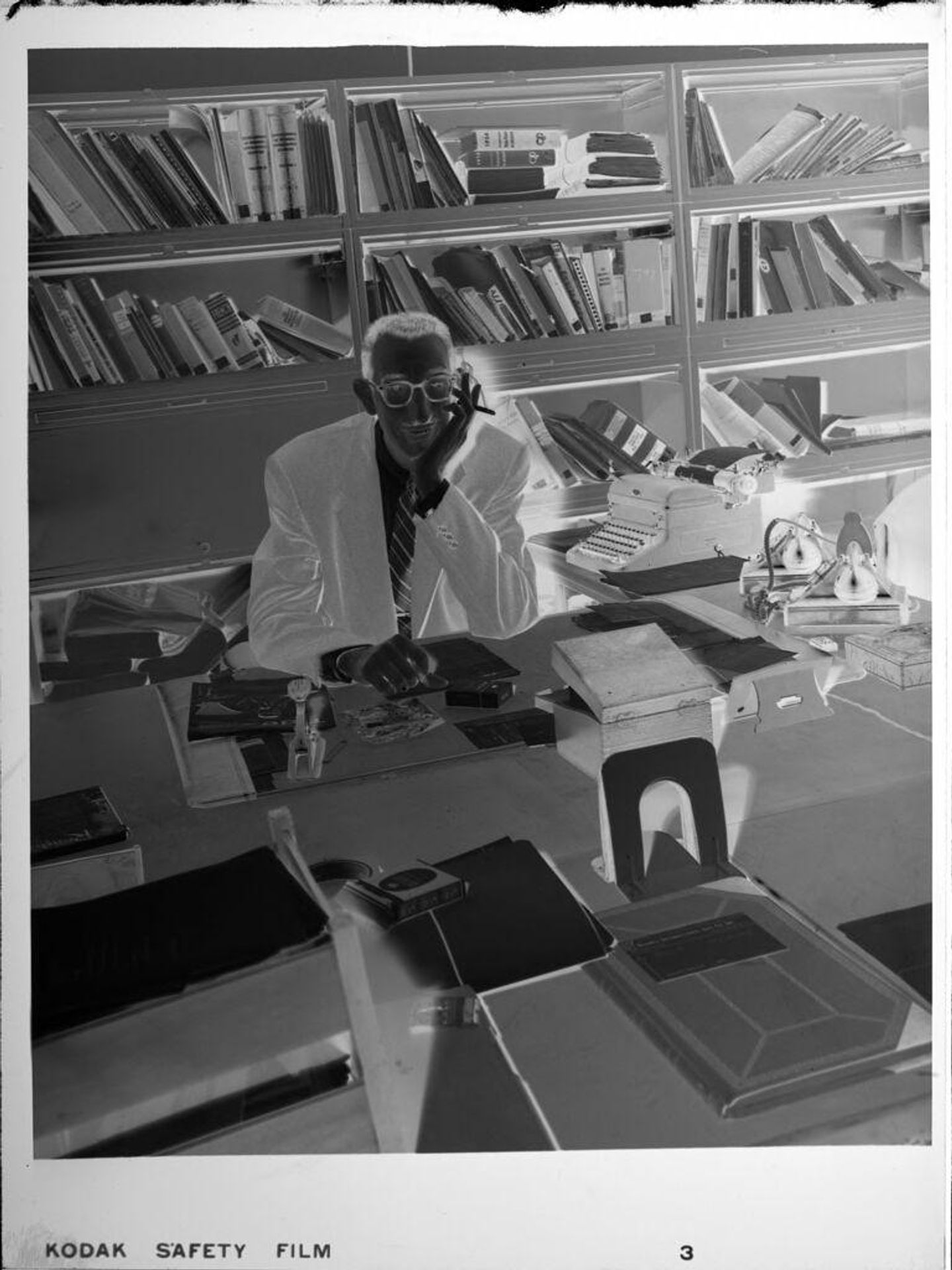 Untitled (man in office with bookshelves) by Peter James Studio