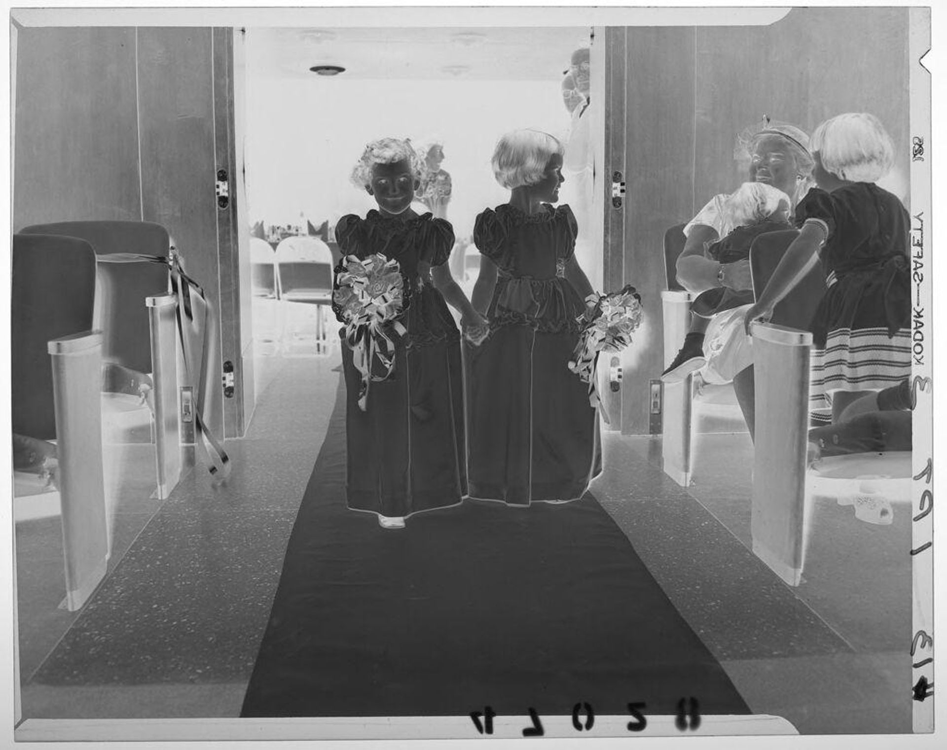 Untitled (two young flower girls walking down wedding aisle) by Martin Schweig