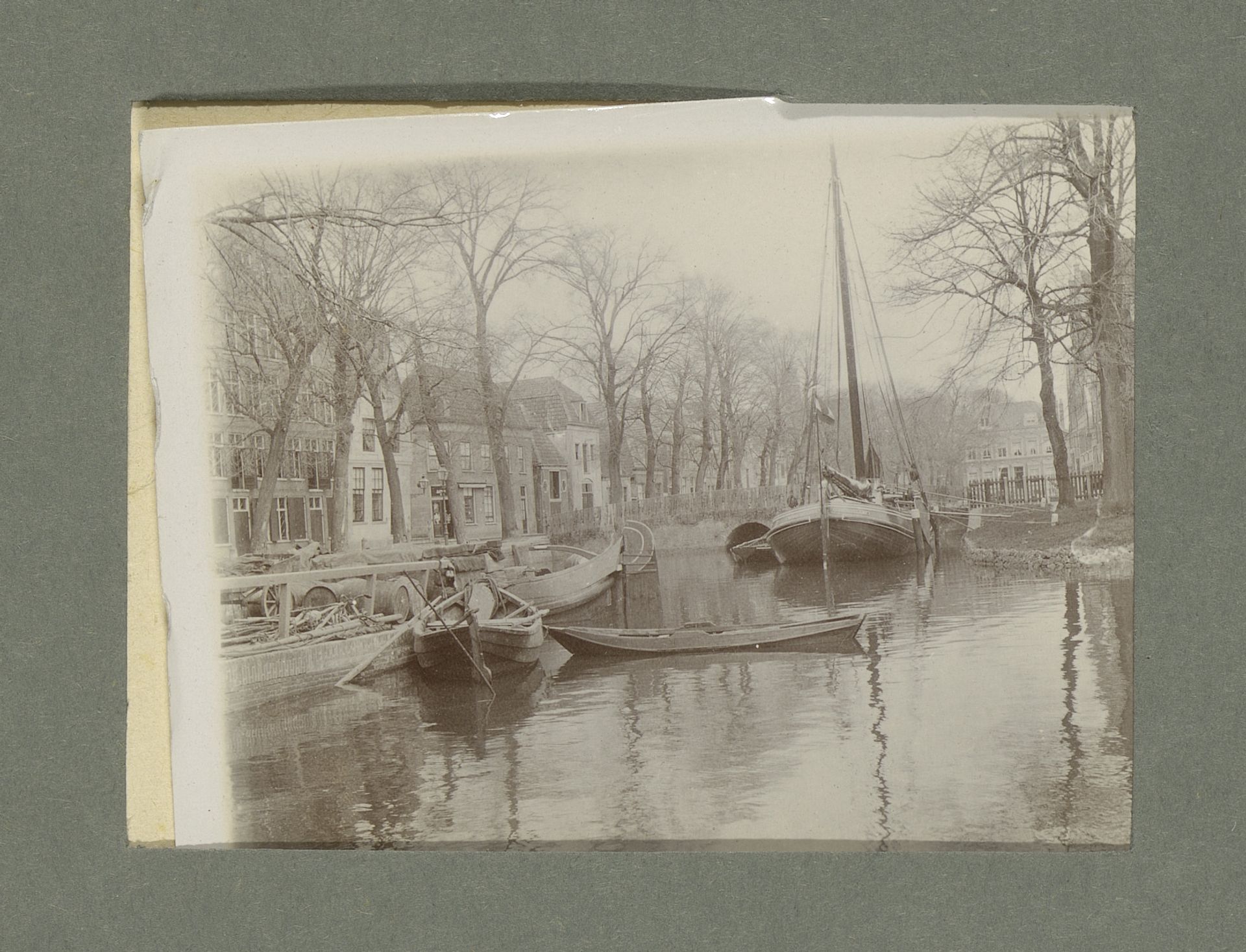 Gezicht op roei- en zeilboten op een water bij een stad of dorp by G. Hidderley