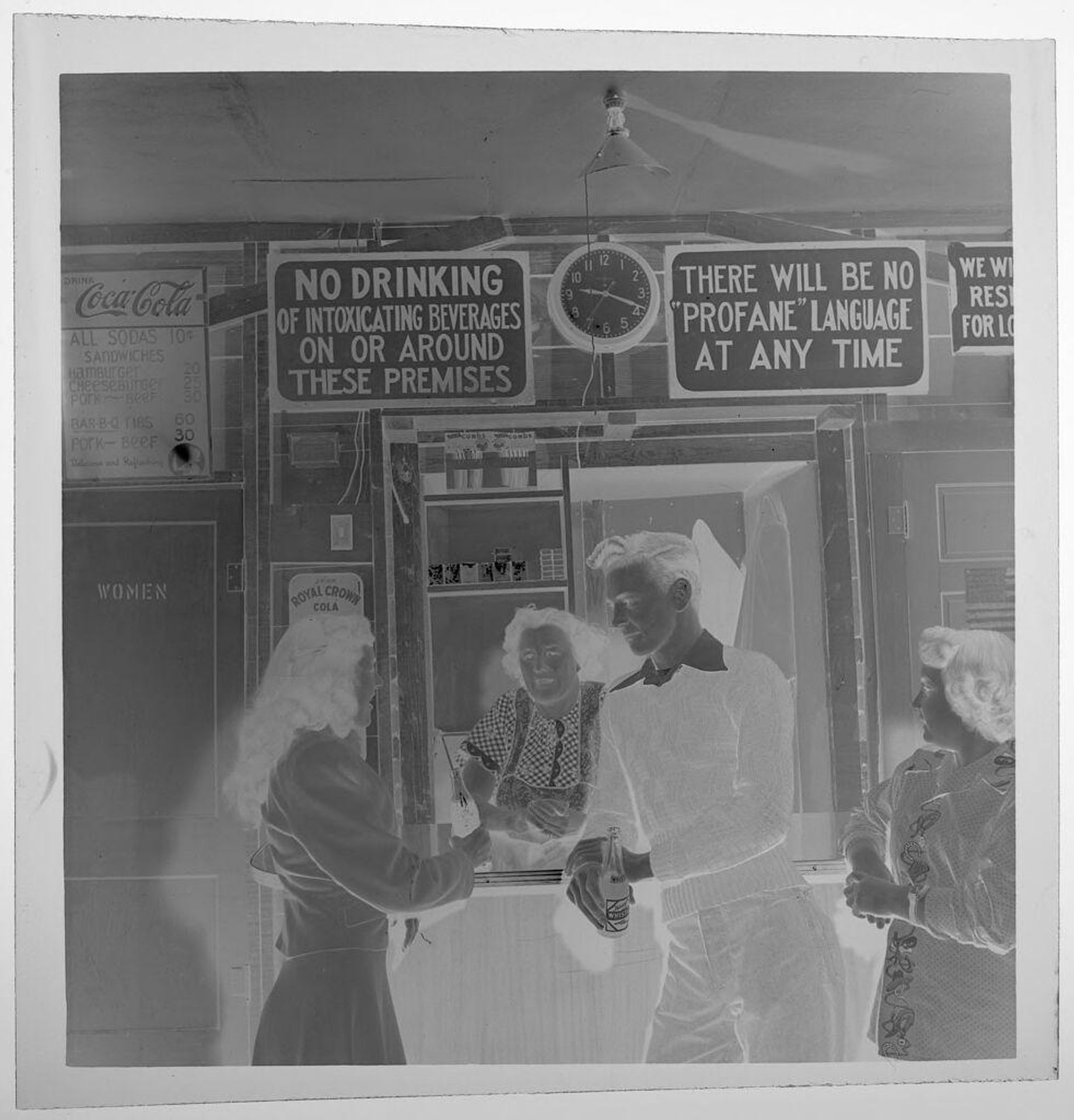 Untitled (boy and girl drinking soda in front of food counter) by Jack Gould
