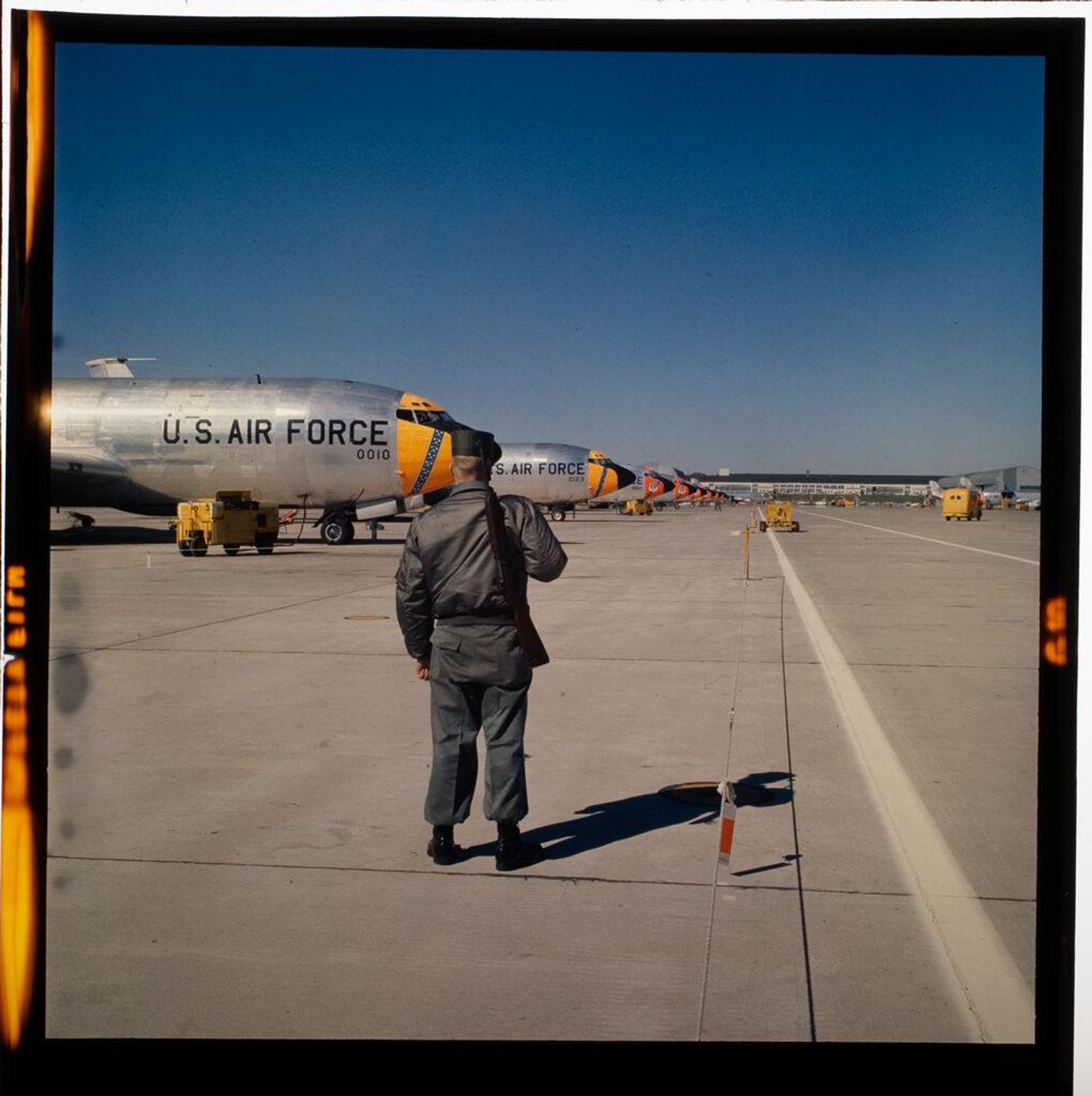 Untitled (man on runway near large Air Force jet) by Jack Gould