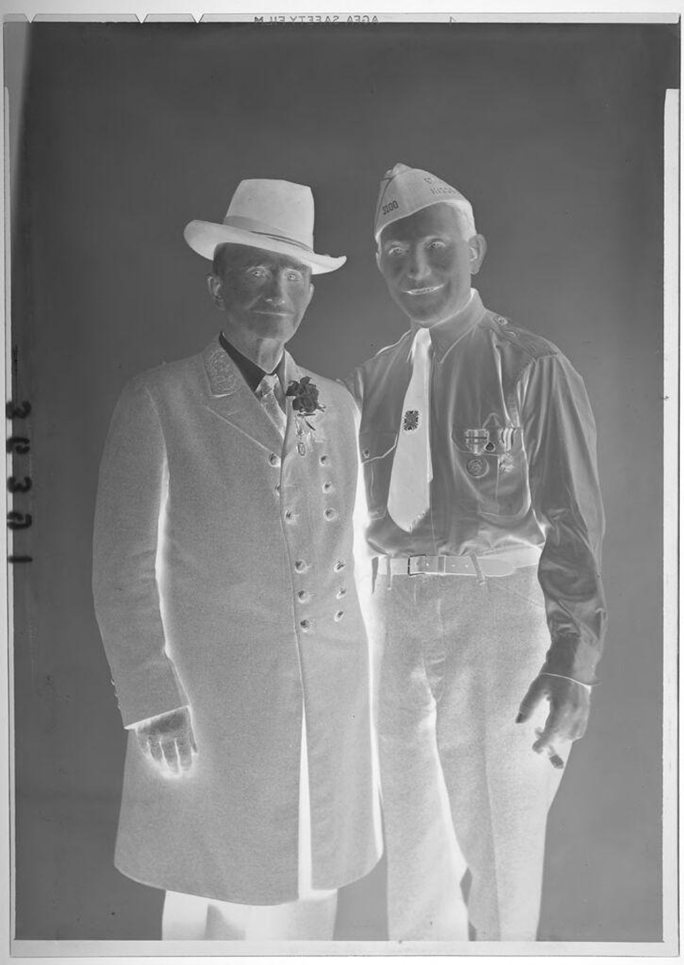 Untitled (studio portrait of two men wearing military pins with one in a jacket and another holding a cigar) by Martin Schweig