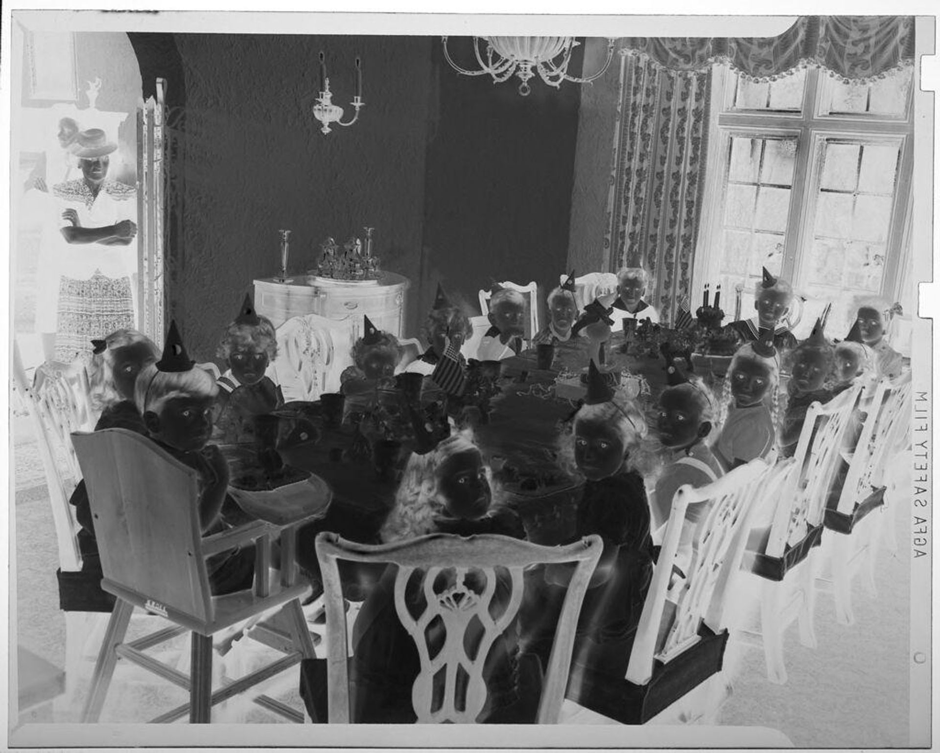 Untitled (children seated around birthday party table with woman standing in doorway of room) by Martin Schweig