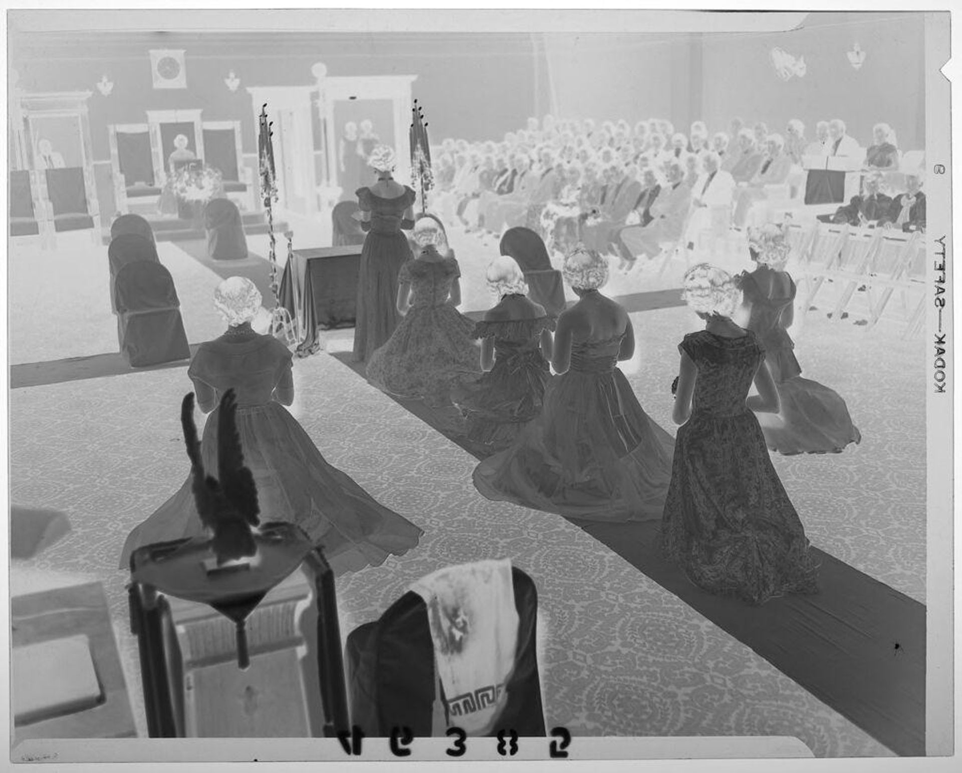 Untitled (seven young women kneeling and standing in Masonic ceremony with audience watching) by Martin Schweig