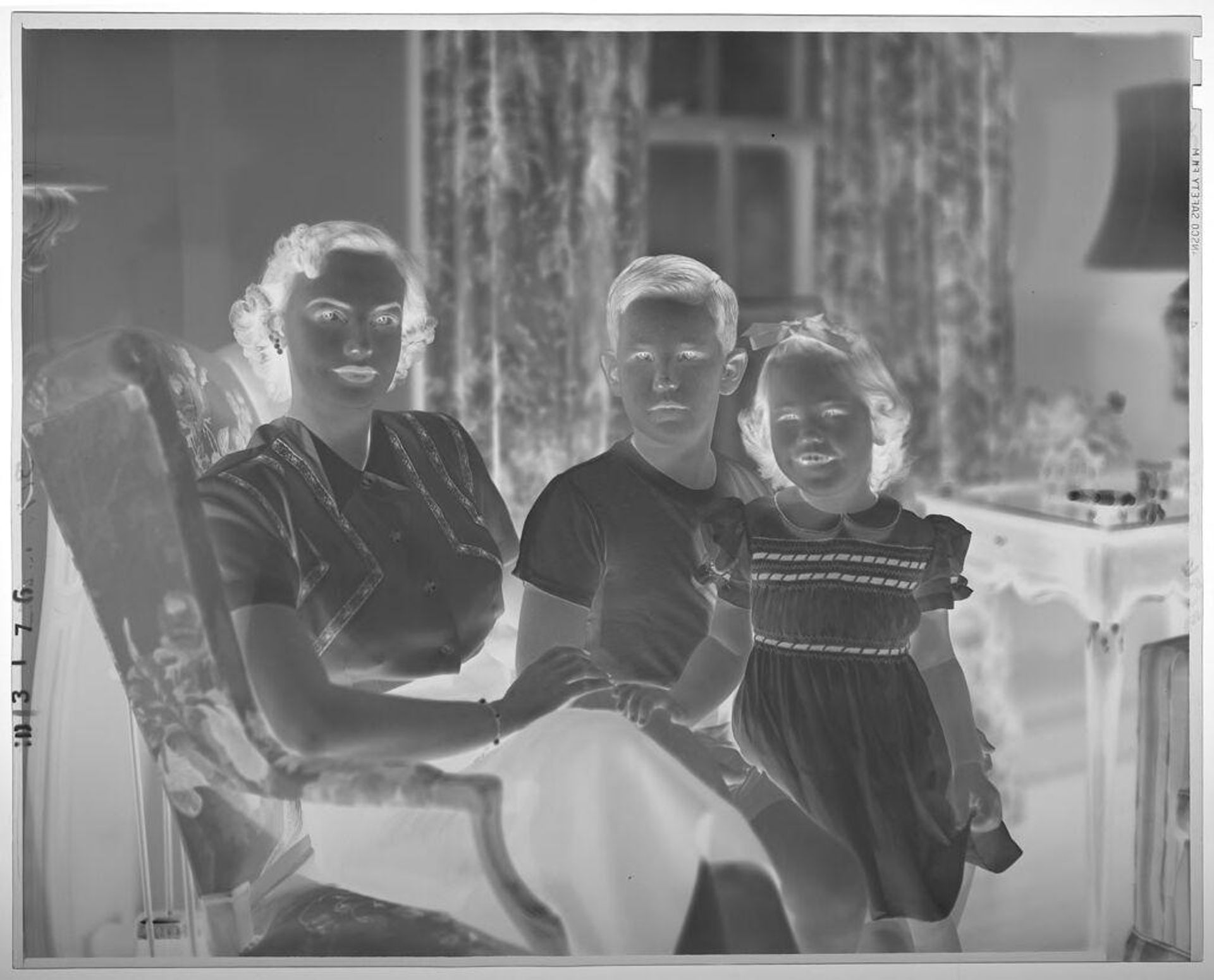 Untitled (mother seated in armchair with son and daughter) by Paul Gittings