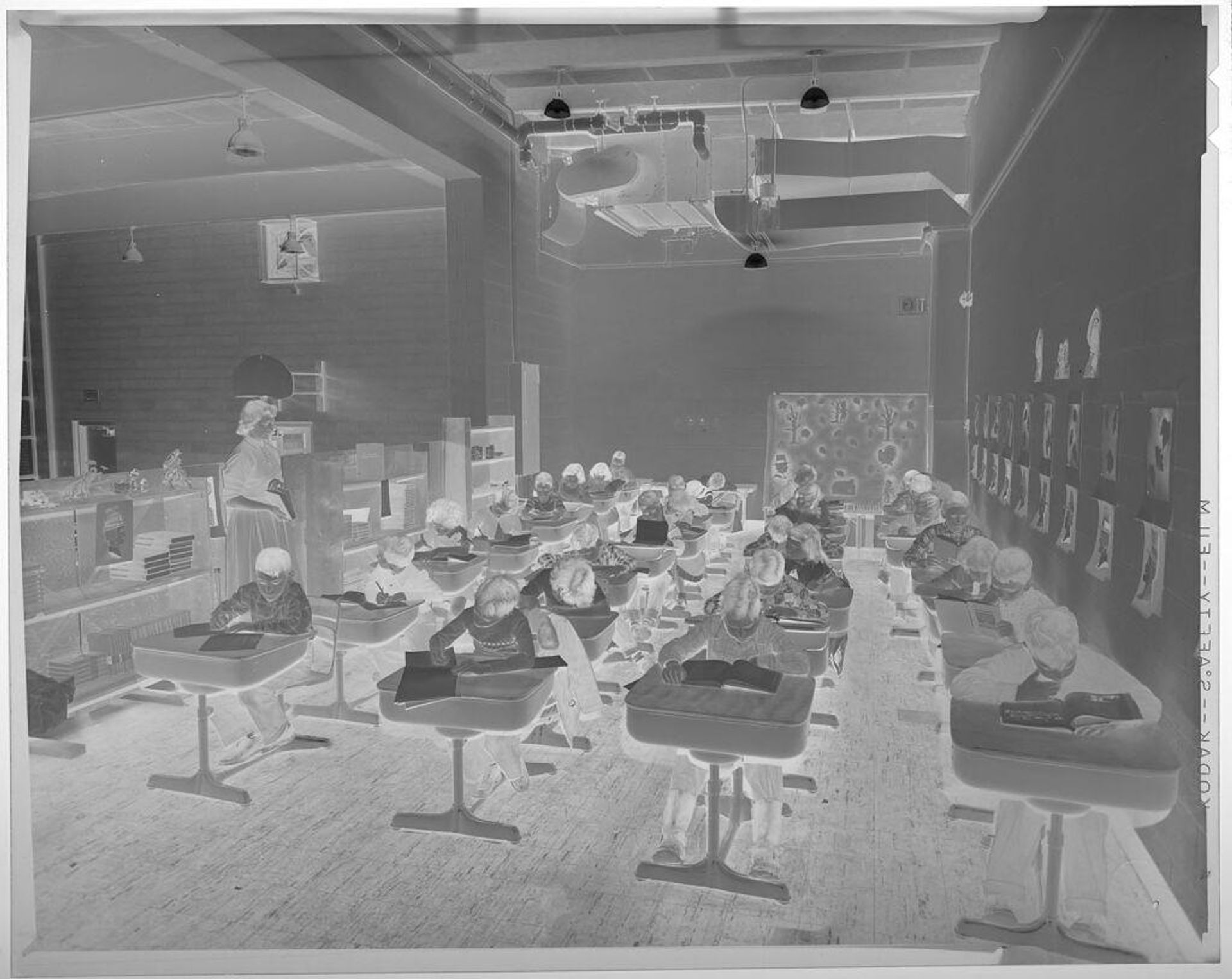 Untitled (elementary school classroom with children and teacher, children at individual desks) by Jack Gould