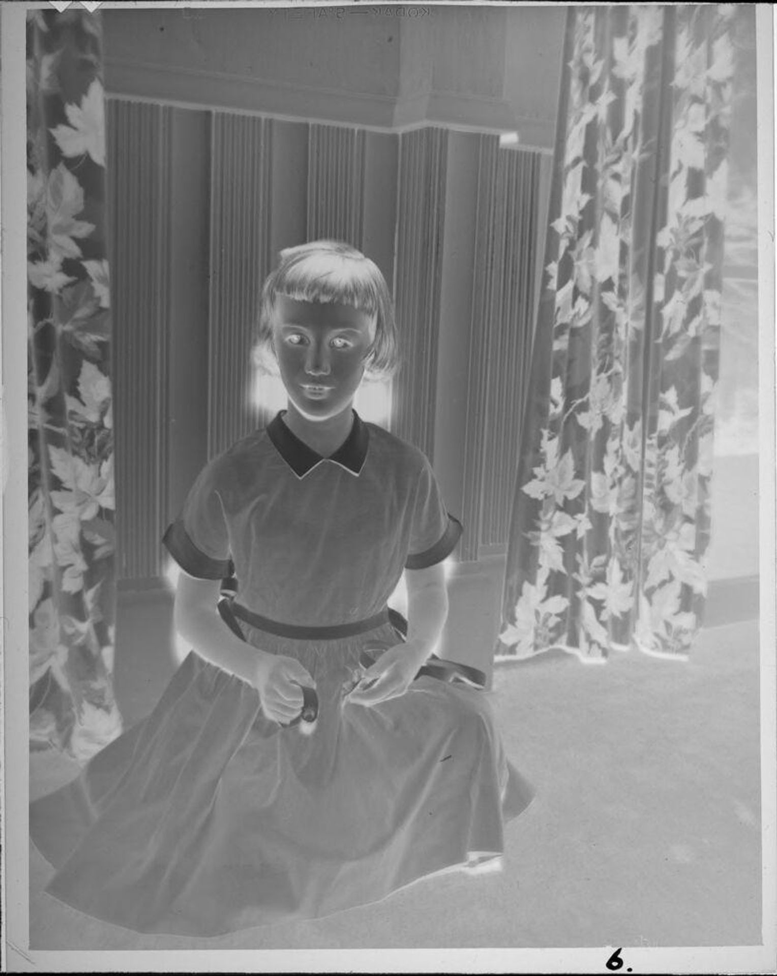 Untitled (girl kneeling in front of curtains) by Lucian and Mary Brown