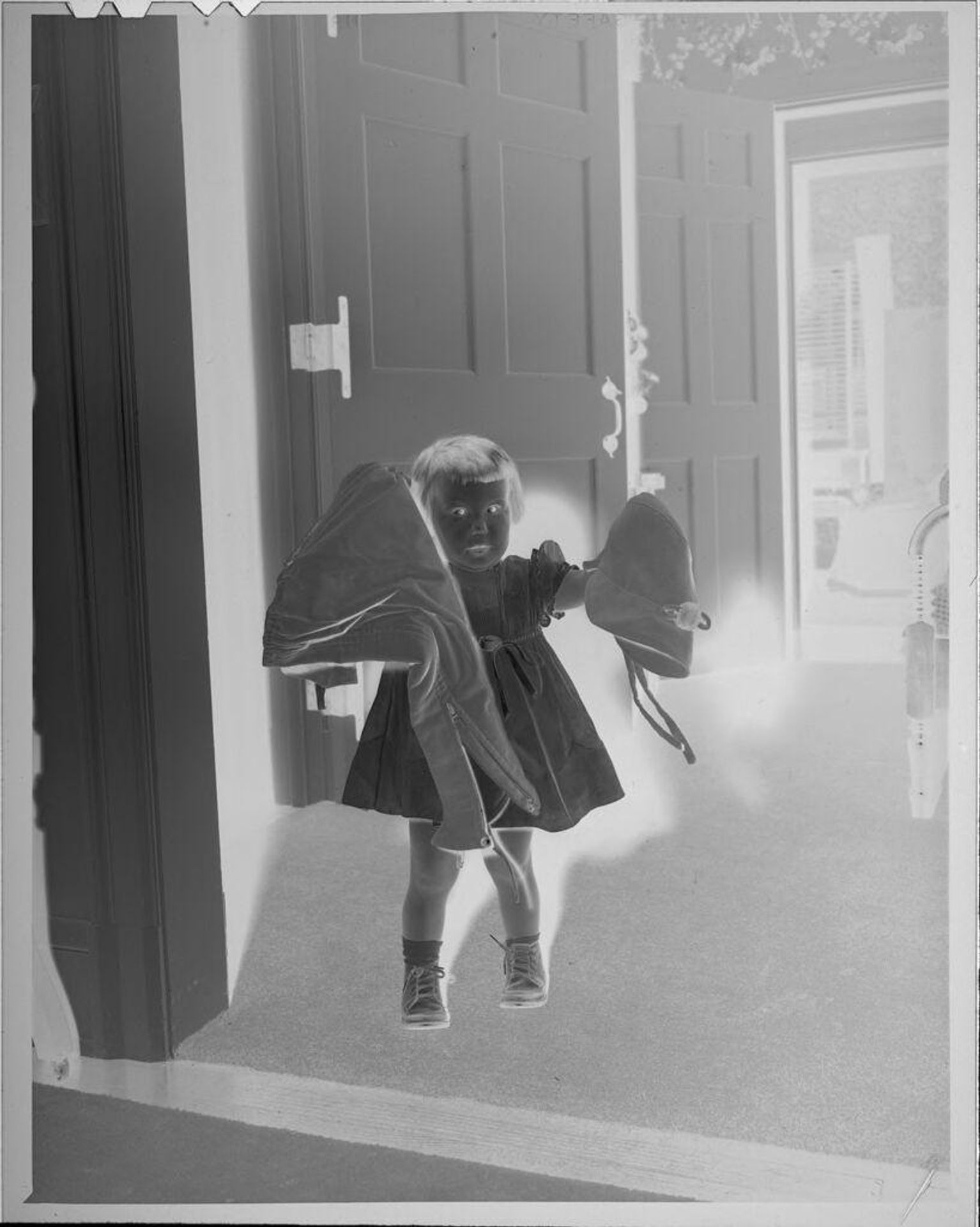 Untitled (little girl holding coat and hat) by Lucian and Mary Brown